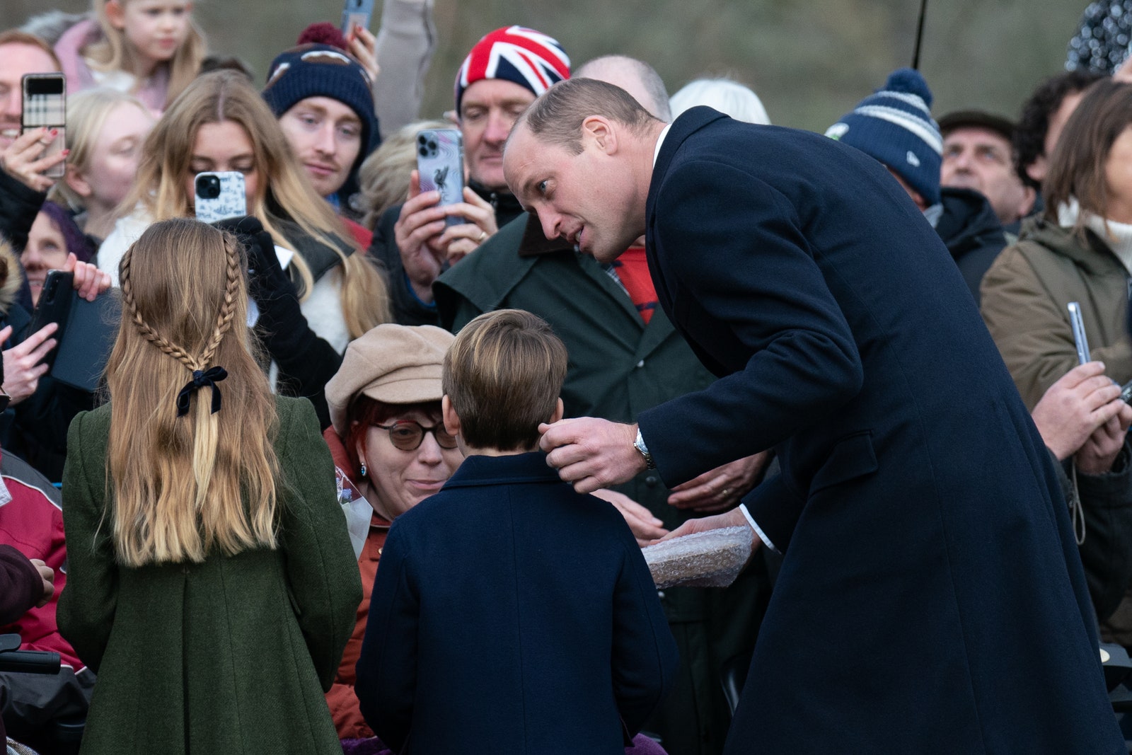 La princesse Charlotte, le prince Louis et le prince de Galles rencontrent des sympathisants après avoir assisté à la matinée du jour de Noël...