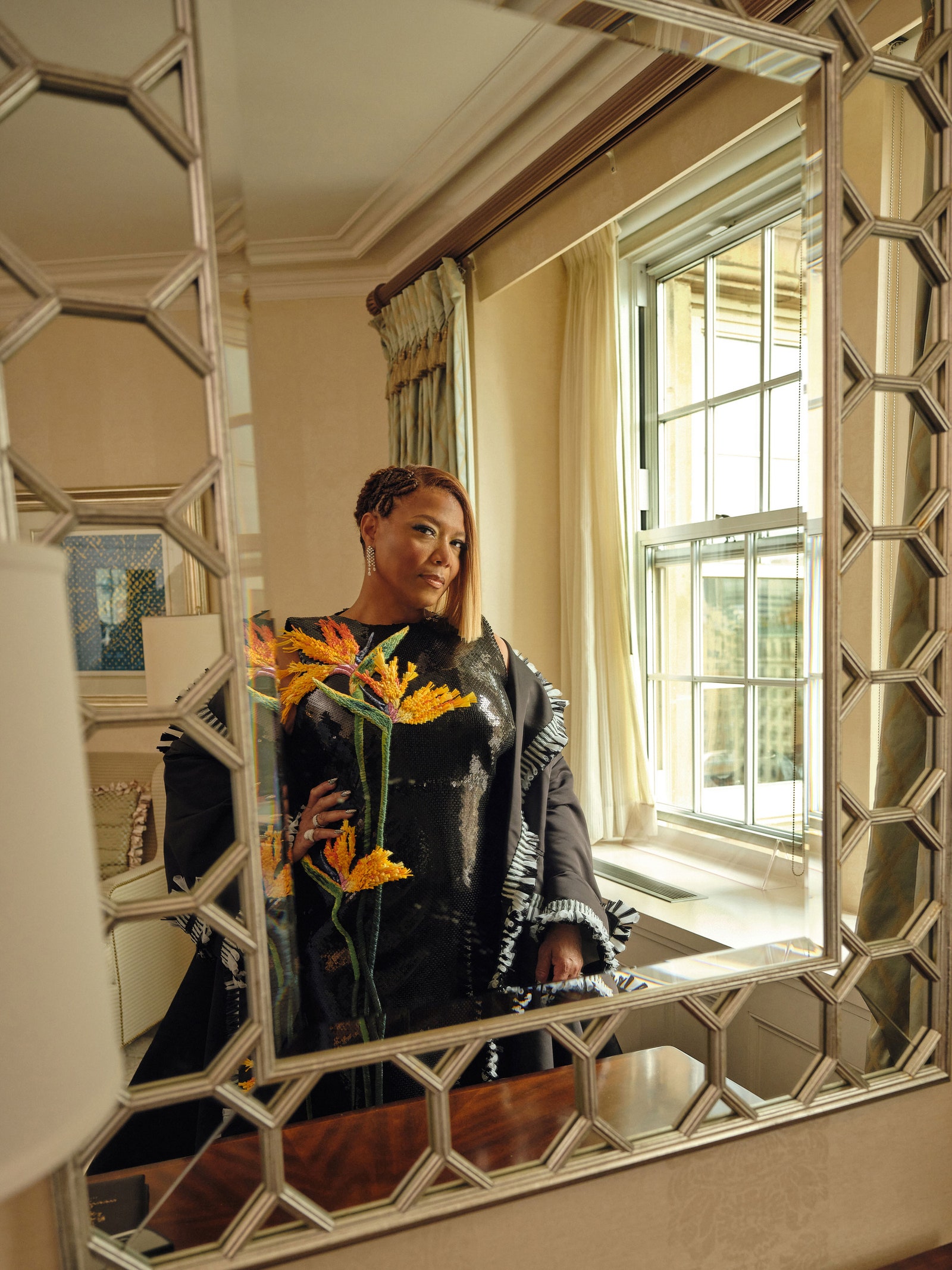 L'image peut contenir des vêtements de Queen Latifah, un manteau, une veste, un visage, une personne, une photographie, un portrait, une marguerite, une fleur et une plante.