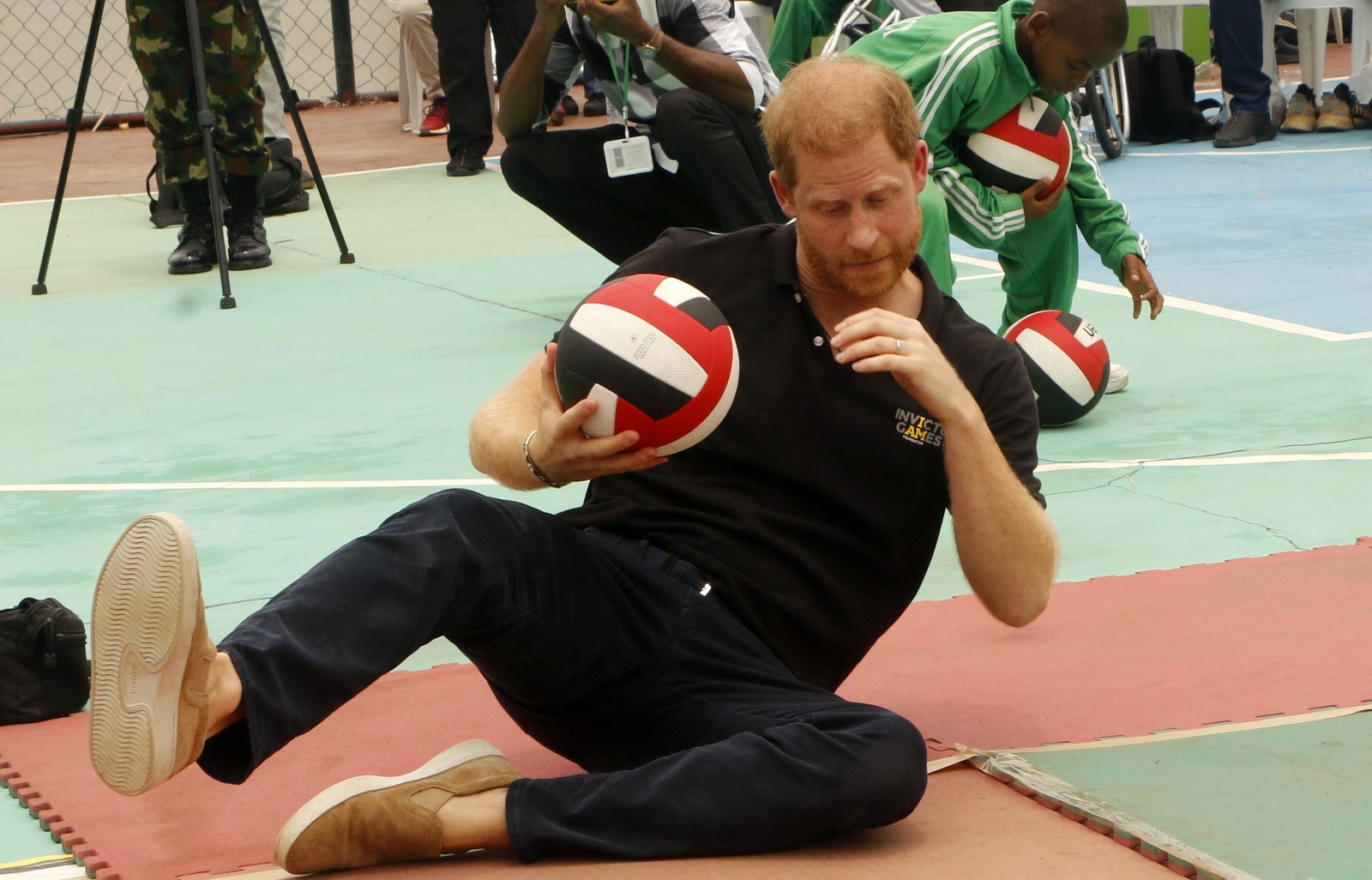 L'image peut contenir le prince Harry, duc de Sussex, vêtements, chaussures, chaussures, ballon, sport, volley-ball et volley-ball.