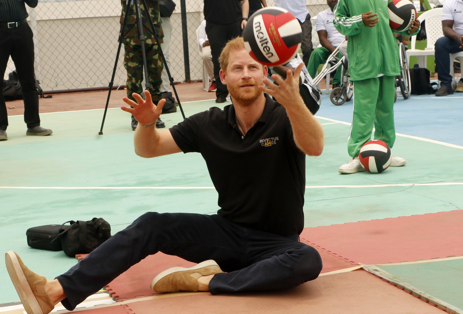 L'image peut contenir le prince Harry, duc de Sussex, vêtements, chaussures, chaussures, personnes adultes, accessoires, sac, sac à main et ballon.