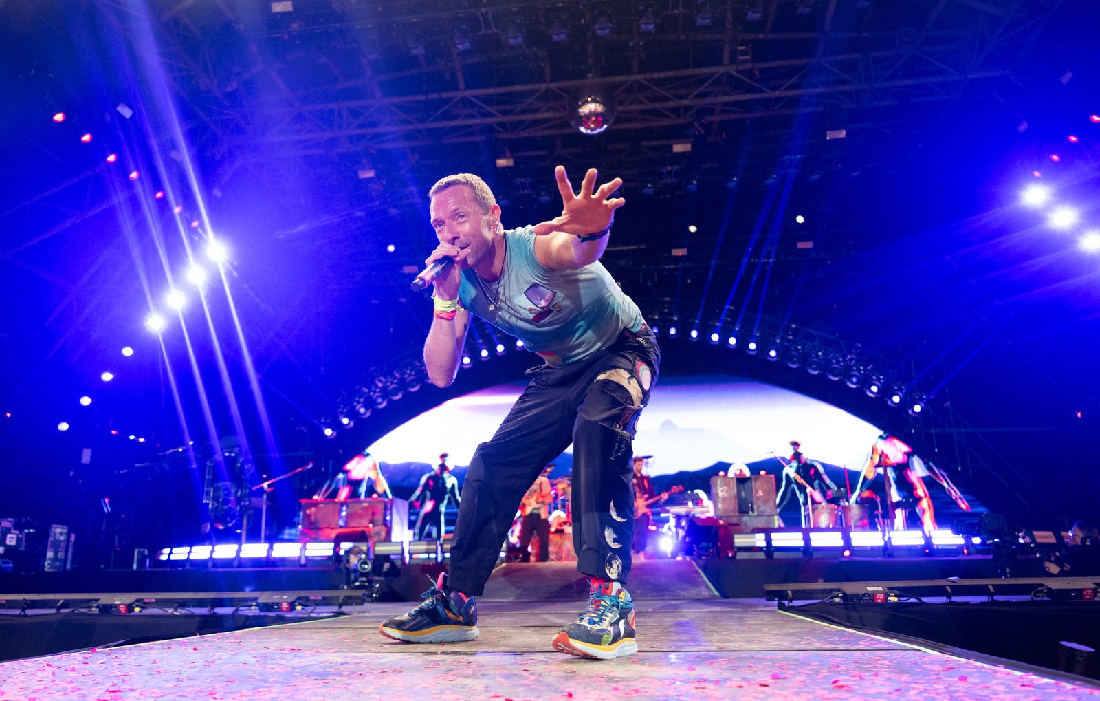 Michael J. Fox joue avec Coldplay pendant son concert à Glastonbury L'image peut contenir Chris Martin Éclairage Interprète Personne Performance solo Vêtements pour adultes Chaussures Chaussure et concert