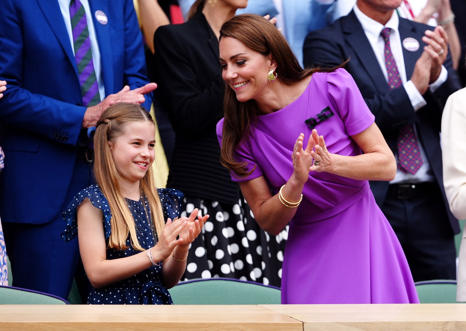 L'image peut contenir des accessoires, des vêtements de cérémonie, des cravates, des bracelets, des bijoux, des enfants, des applaudissements, des adultes, des ceintures et des chaises de mariage