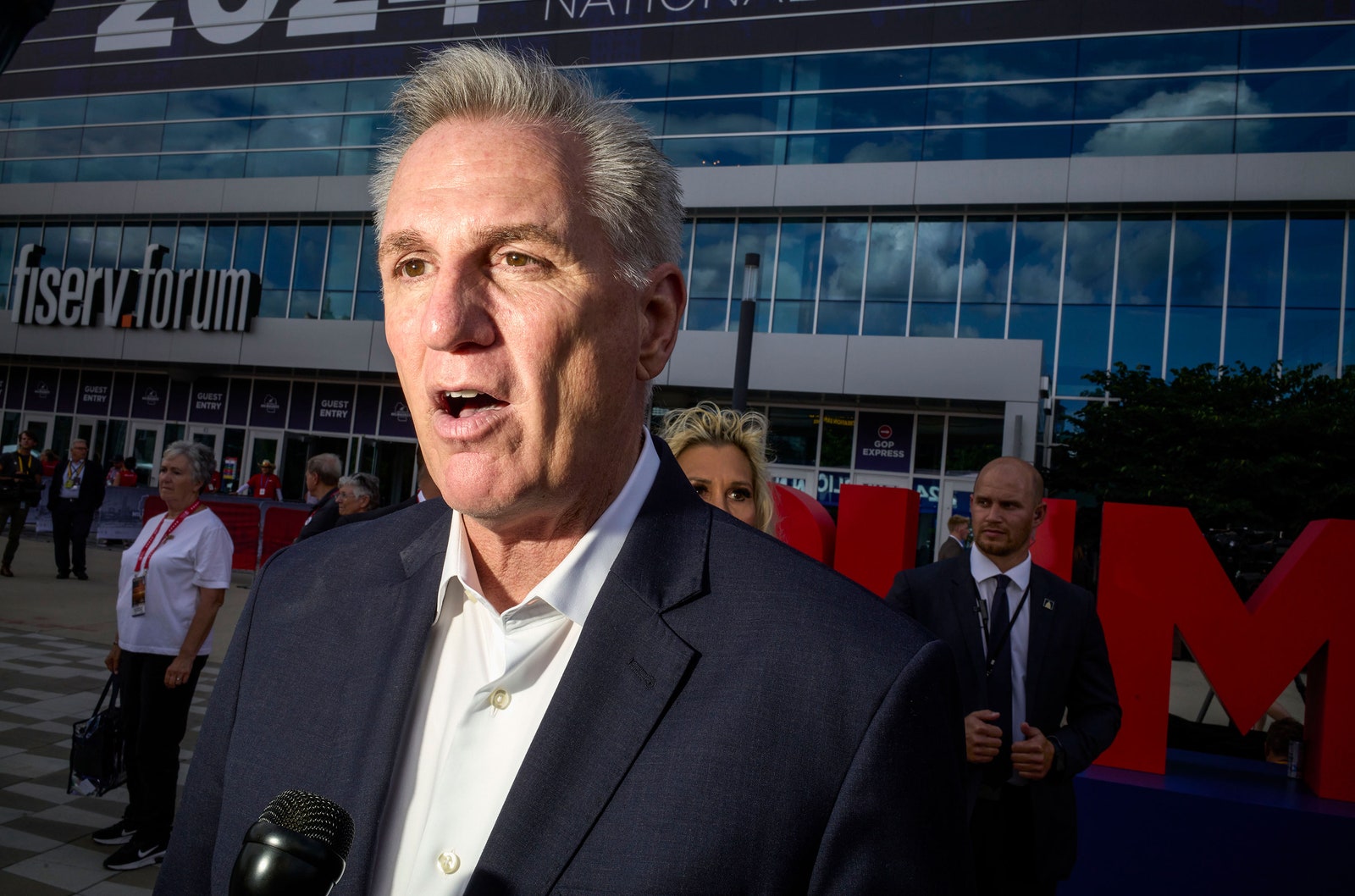 L'image peut contenir Kevin McCarthy Personnes Personne Foule Accessoires Sac Sac à main Appareil électrique Microphone et Adulte