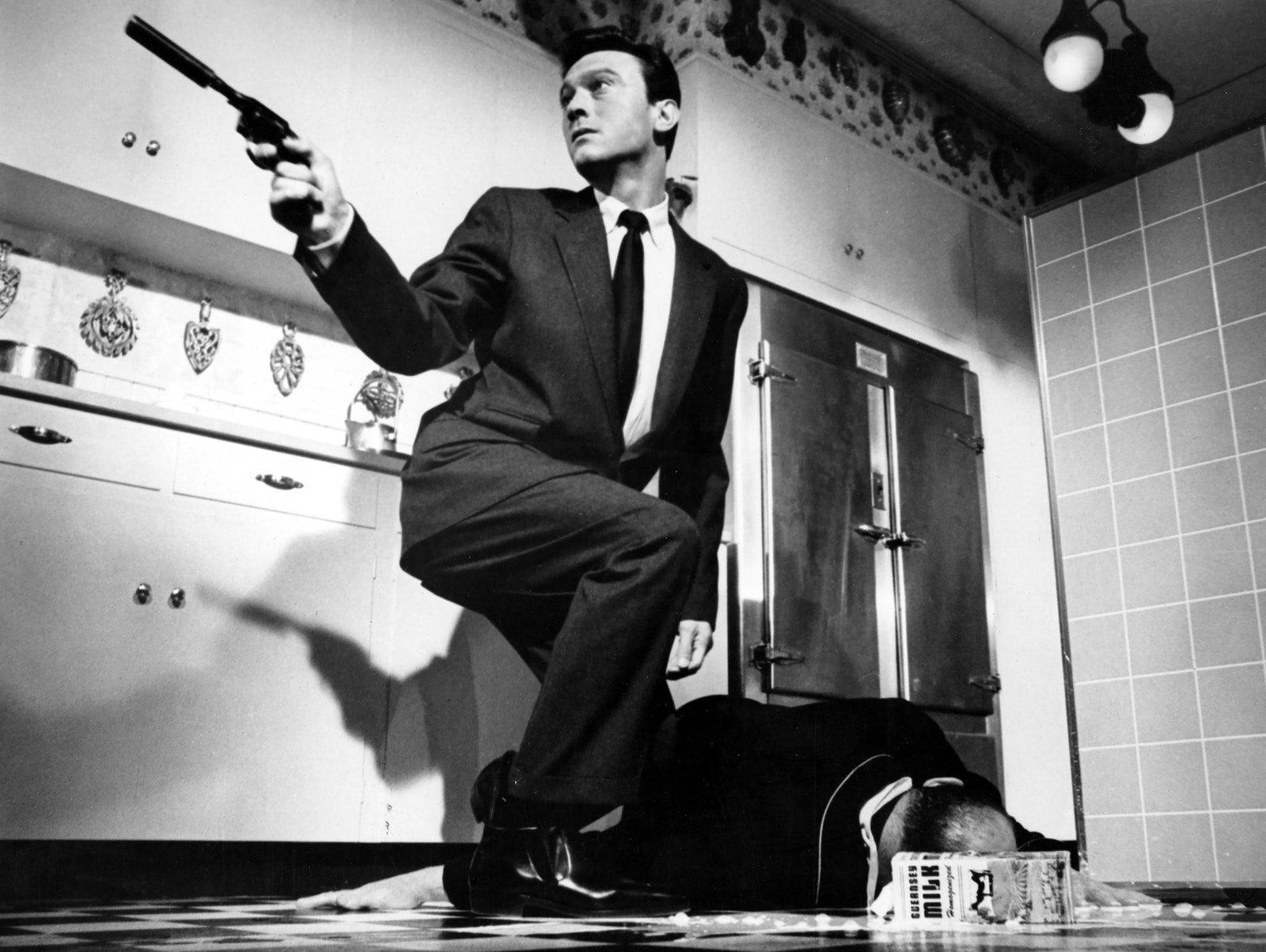 L'image peut contenir Laurence Harvey Arme à feu Personne adulte Pistolet Accessoires pour armes de poing Tenue de soirée et cravate