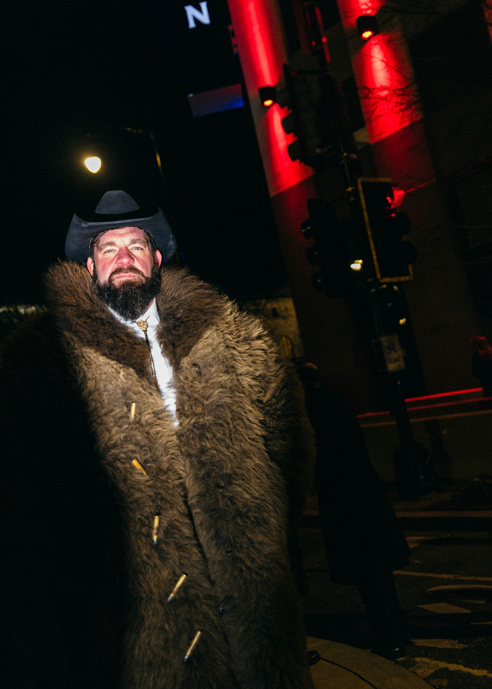 L'image peut contenir des vêtements Manteau Éclairage Visage Tête Personne Photographie Portrait Veste Ville Route Rue et Urbain