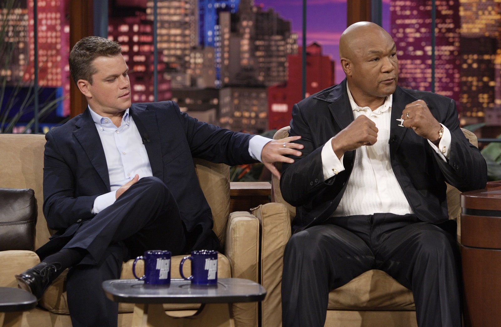 L'image peut contenir George Foreman Matt Damon Conversation Person Person Cup Cup Interview Adult Vêtements Footwear and Shoe