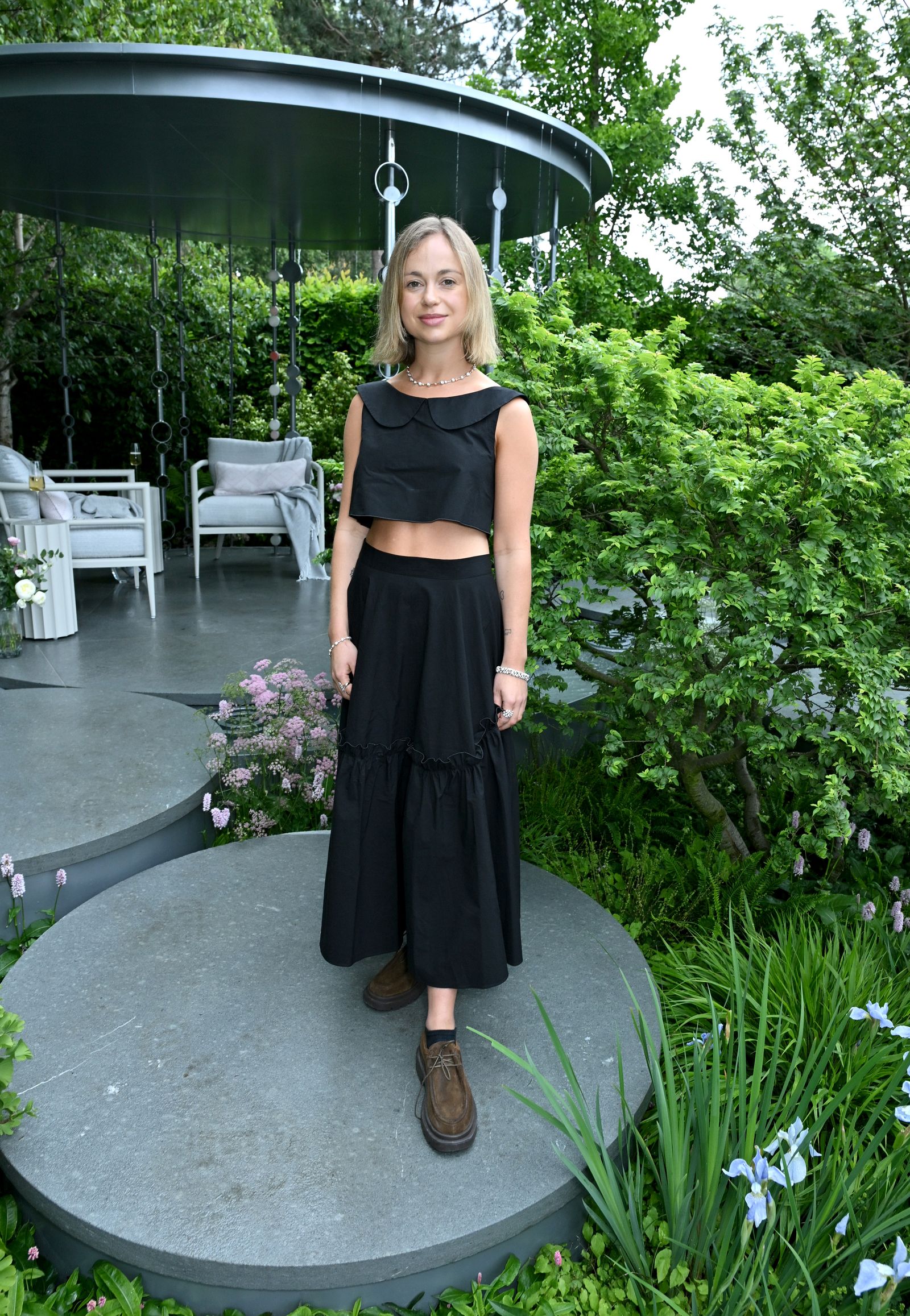 L'image peut contenir des vêtements de robe personne debout dans le jargot de la nature à l'extérieur