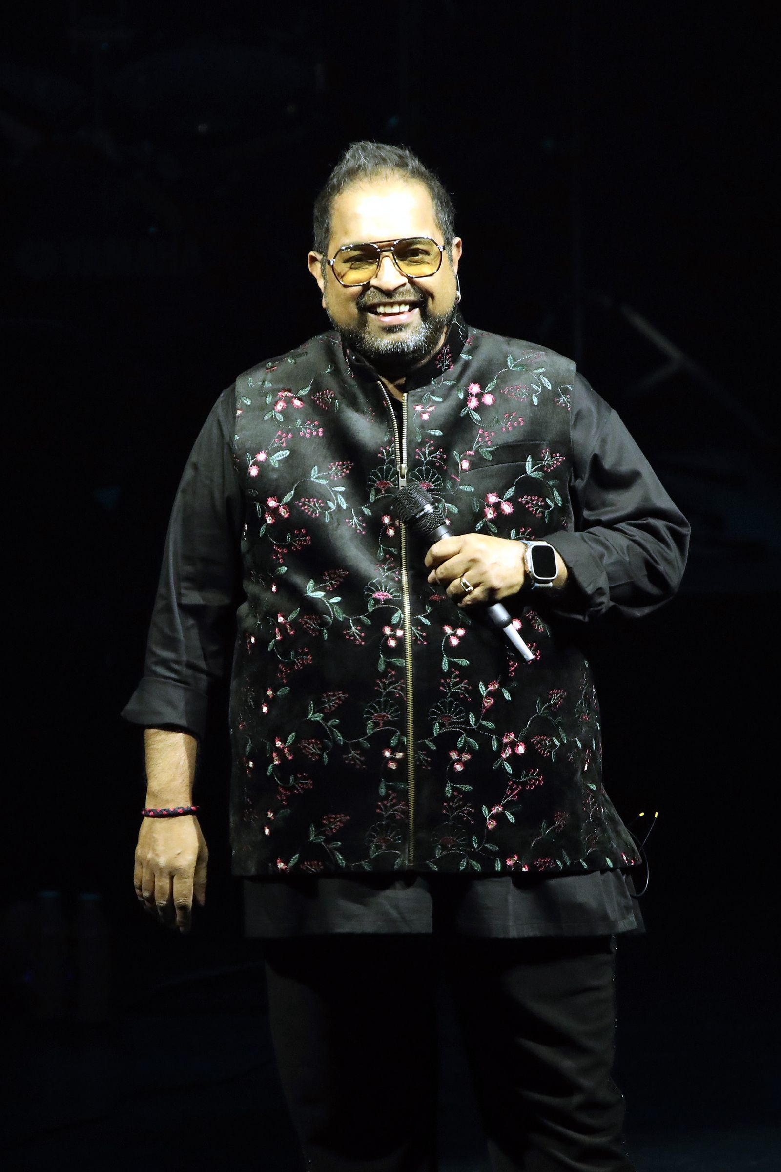 L'image peut contenir des performances Shankar Mahadevan Personnes en solo Performance électrique Dispositif Microphone Vêtements et manteau