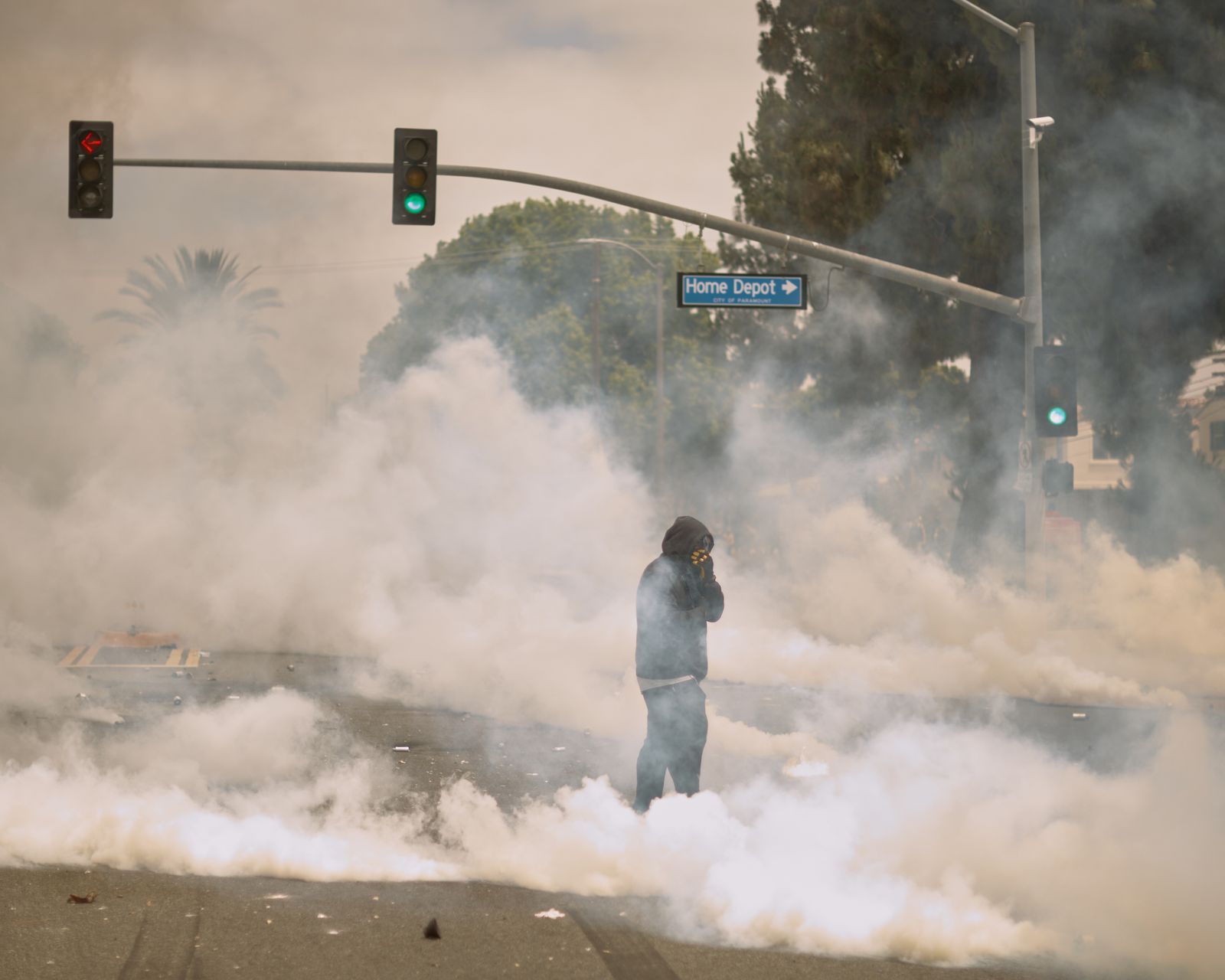 Un manifestant debout dans la fumée à Los Angeles