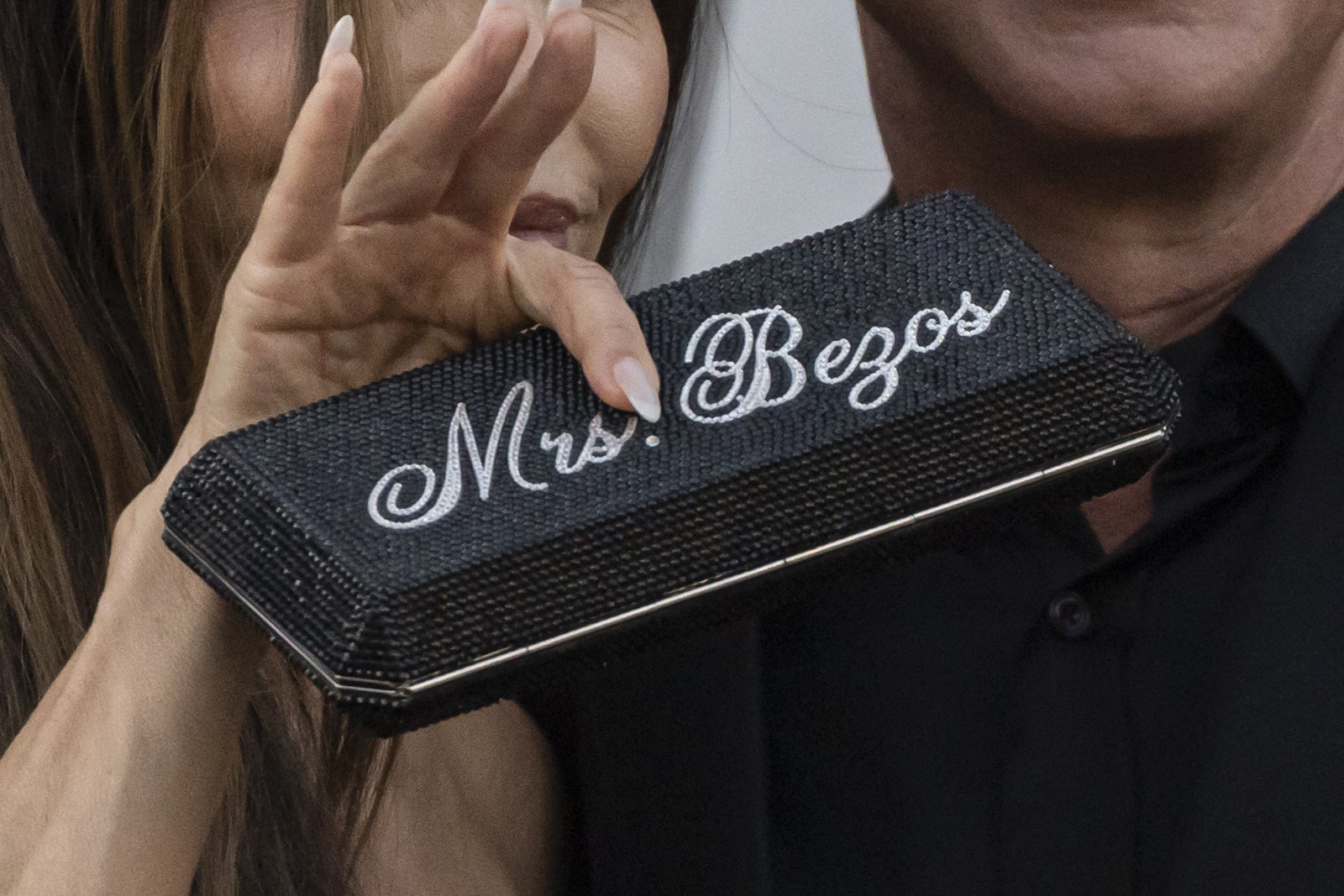 L'image peut contenir des accessoires de personne à main de partie du corps portefeuille et adulte