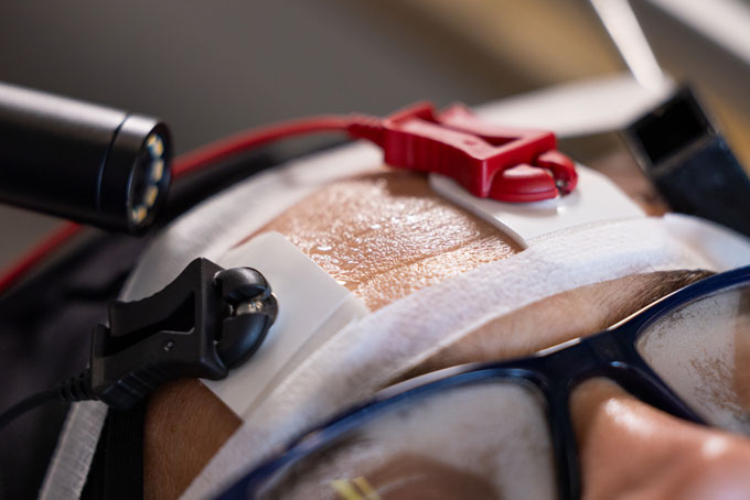 Oubliez des gouttelettes discrètes. C'est comme ça que la sueur se forme vraiment Un gros plan du front d'une personne montre la sueur qui commence à se mettre en commun. Instruments à mesurer qui sont attachés à la personne.