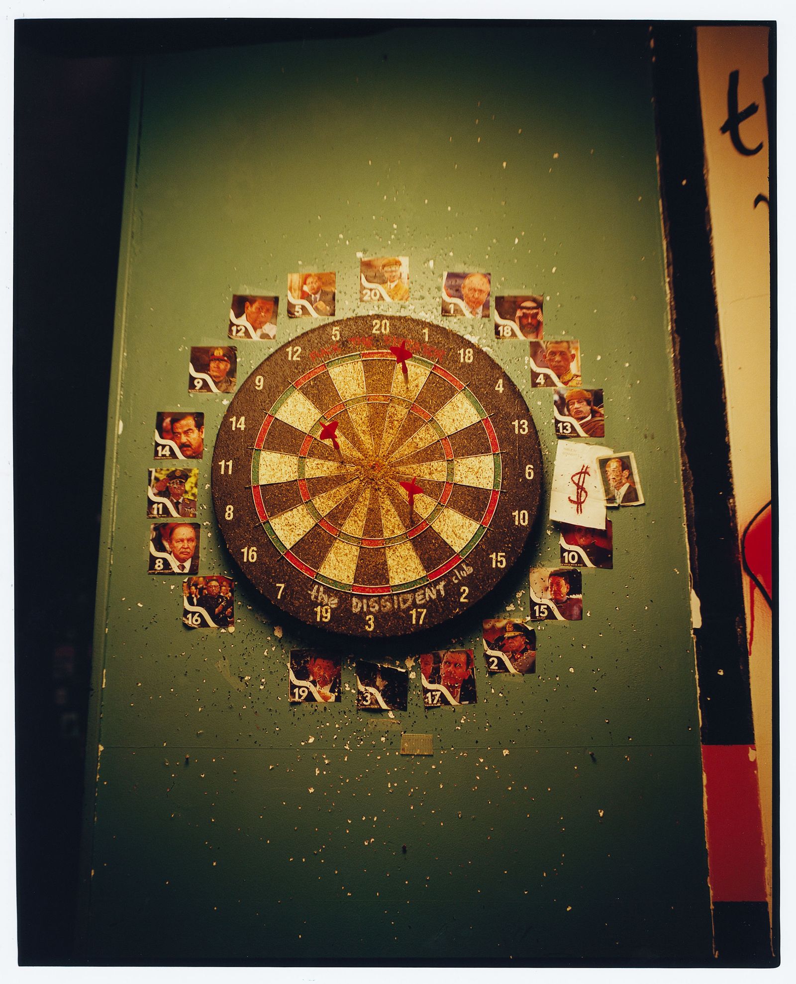 Un plancher entouré de photos de divers dirigeants autoritaires, notamment Vladimir Poutine et Mouammar Kadhafi.