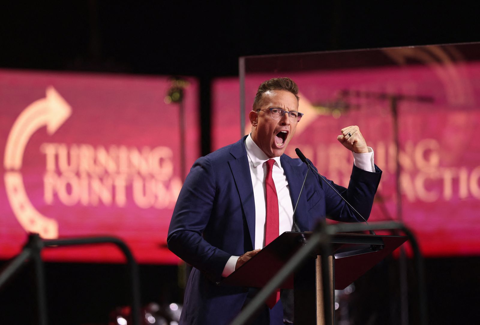 Le commentateur de droite Benny Johnson parle lors du service commémoratif public pour Charlie Kirk.