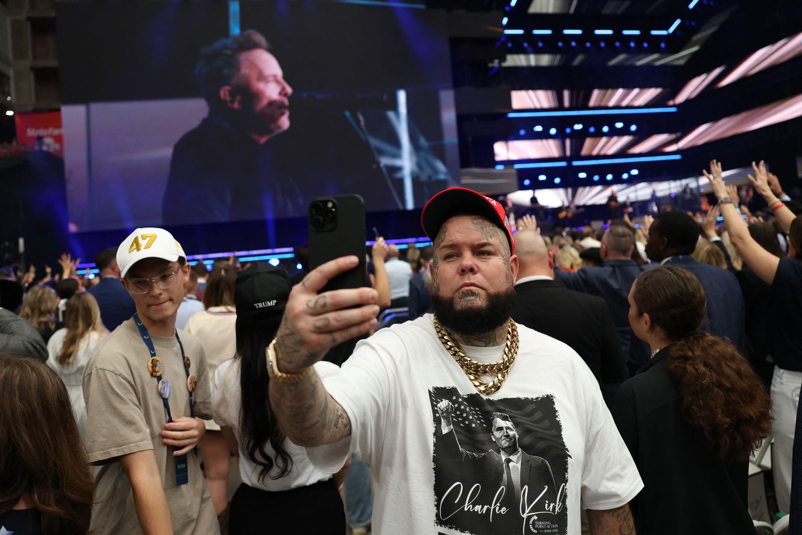 Un participant prend un selfie au service commémoratif de Charlie Kirk.