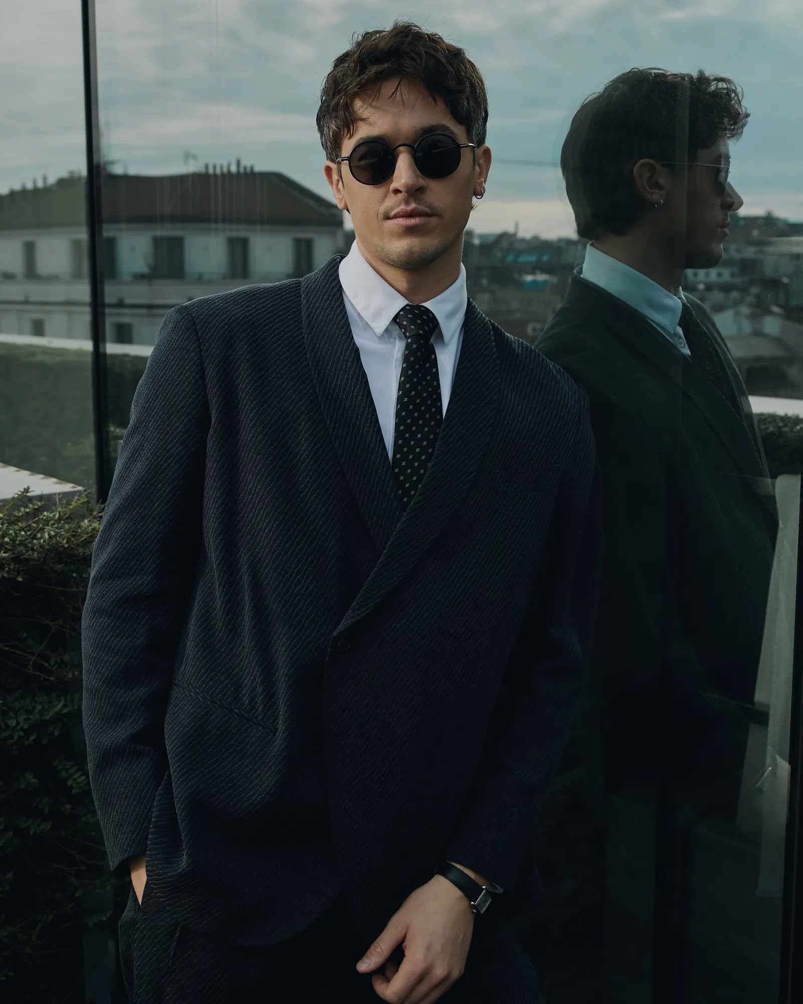 L'image peut contenir un blazer, un manteau, une tenue de soirée, une veste, des accessoires de costume, une cravate, une personne adulte, un smoking et des lunettes de soleil.