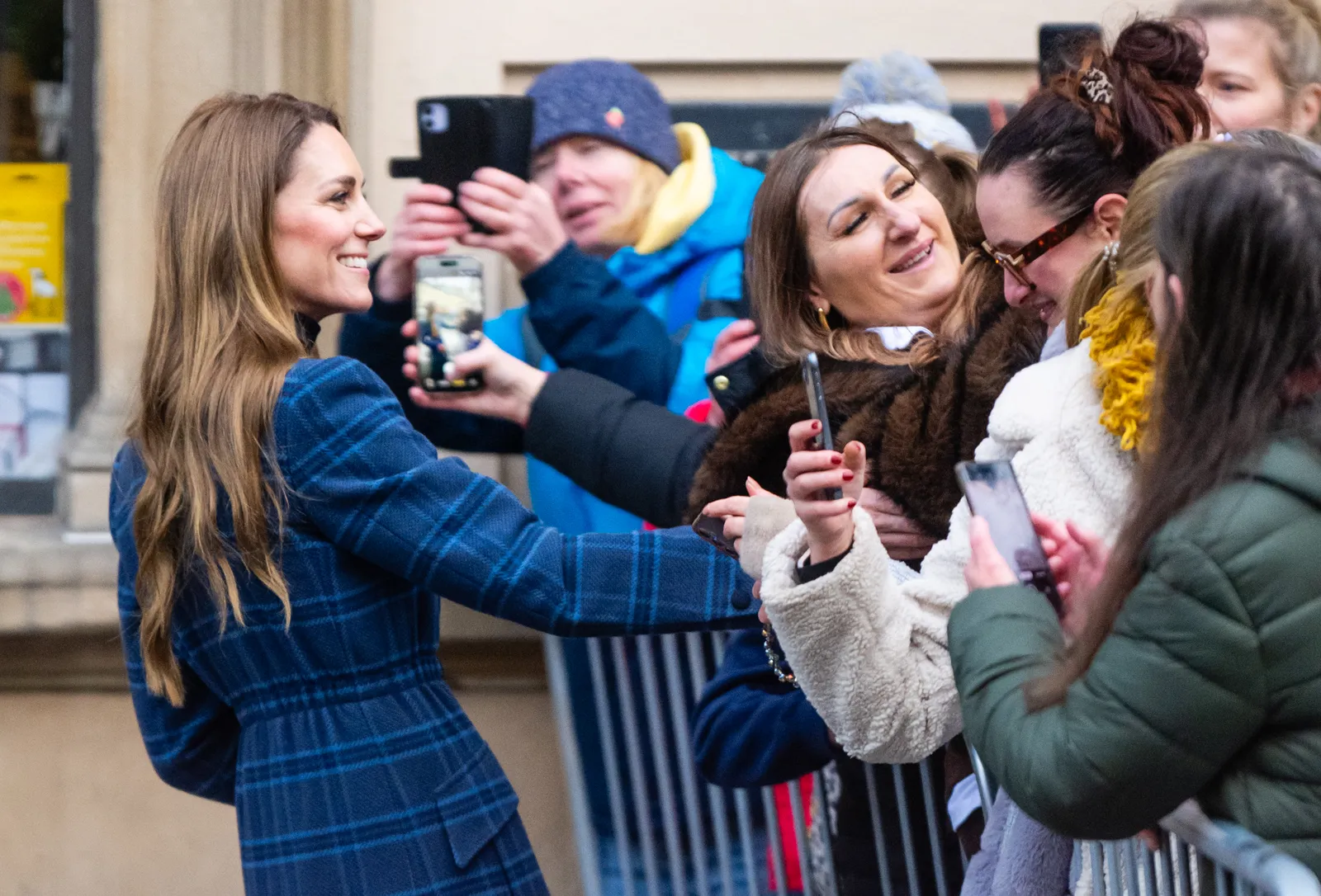 L'image peut contenir une partie du corps doigt main personne électronique téléphone vêtements pour adultes manteau téléphone portable et photographie