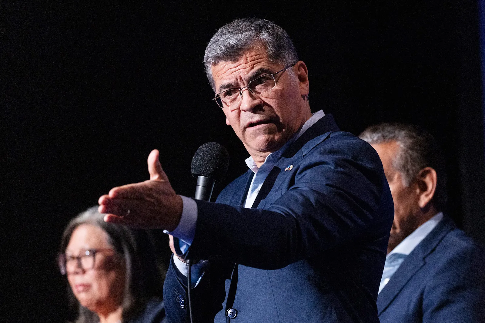 L'image contient peut-être Xavier Becerra Appareil électrique Microphone Personnes Personne Foule Adulte Visage Tête et Photographie