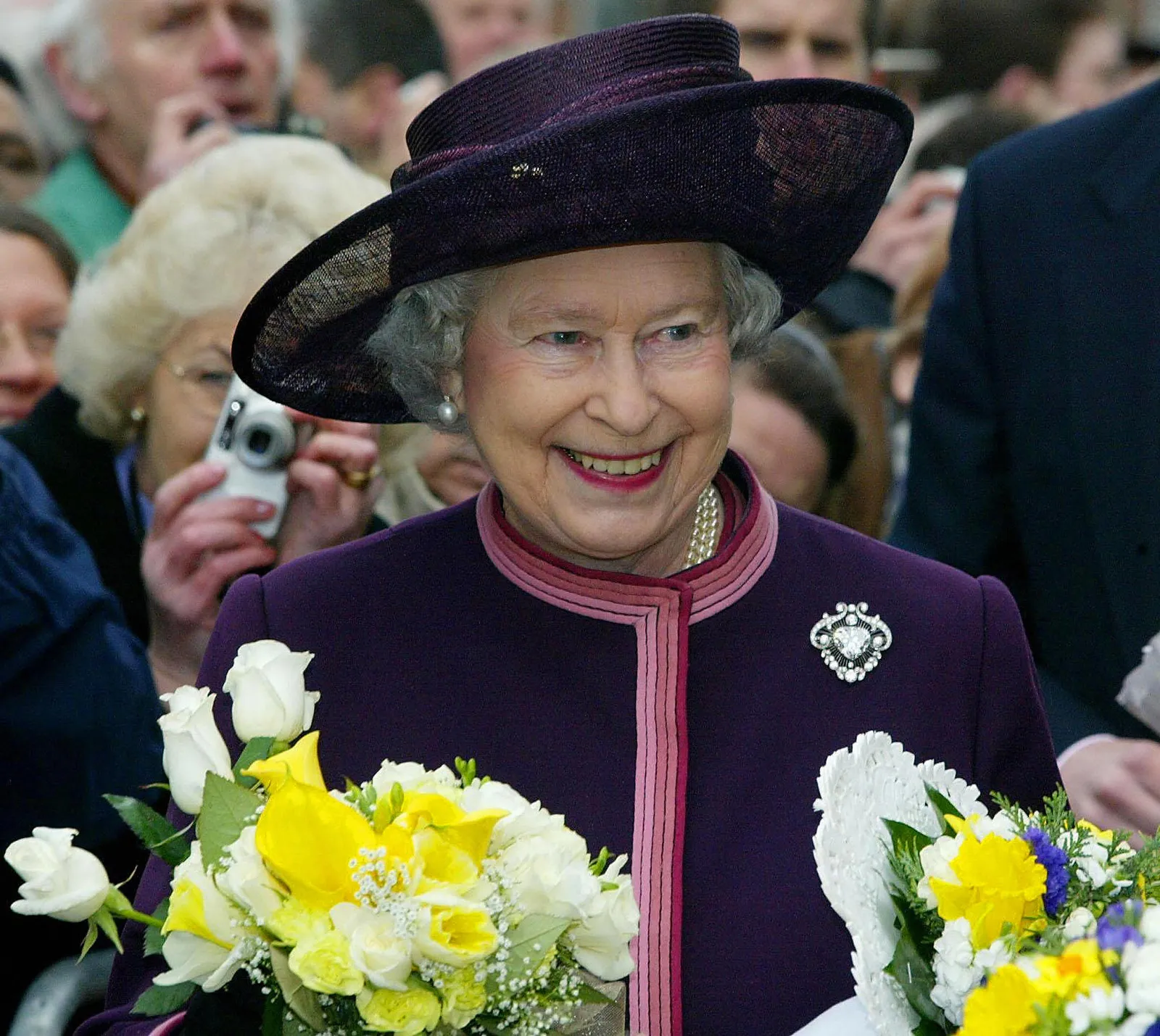 L'image peut contenir Elizabeth II Personne Fleur Arrangement floral Plante Vêtements Chapeau Bouquet de fleurs Adulte et Mariage