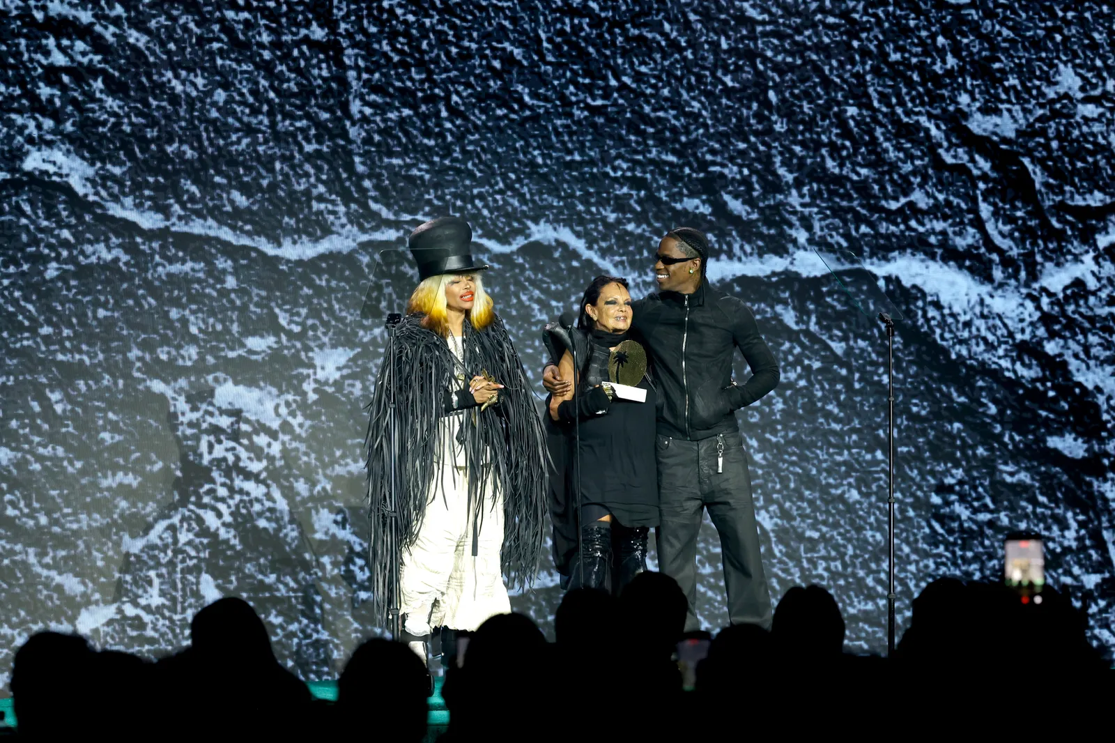 Michèle Lamy, Iconoclaste de la Mode, sur le Striptease, l'Intelligence Artificielle, Rick Owens et Zohran Mamdani L'image peut contenir Travis Scott Mumtaz Erykah Badu Personne adulte Casque Vêtements Manteau Accessoires et lunettes