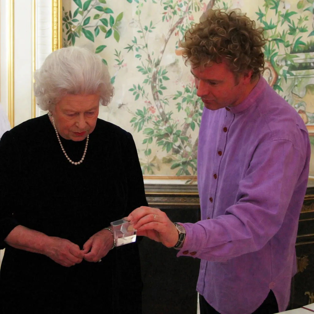 L'image peut contenir une partie du corps d'Elizabeth II, un doigt, une main, une personne, un visage adulte, une tête et des accessoires.