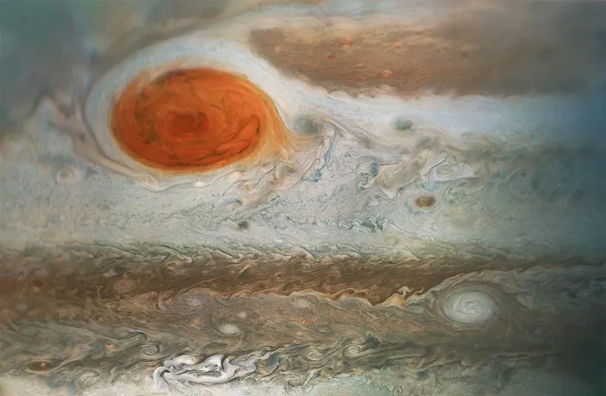 La grande tache rouge de Jupiter apparaît comme une grande tempête rougeâtre au milieu de bandes nuageuses tourbillonnantes.
