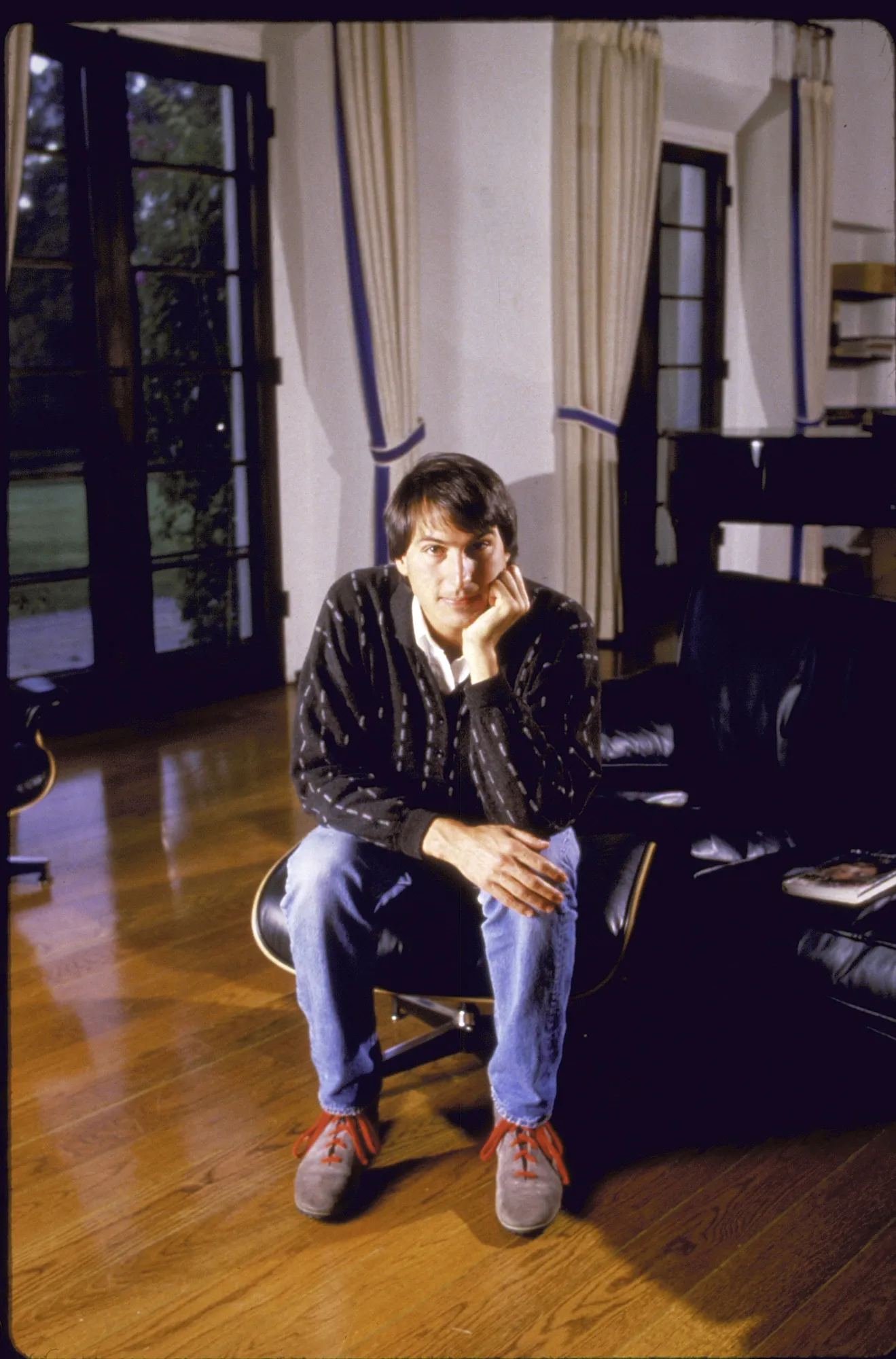 L'image peut contenir Steve Jobs Personne assise Vêtements Pantalon Canapé Meubles Architecture Bâtiment et intérieur