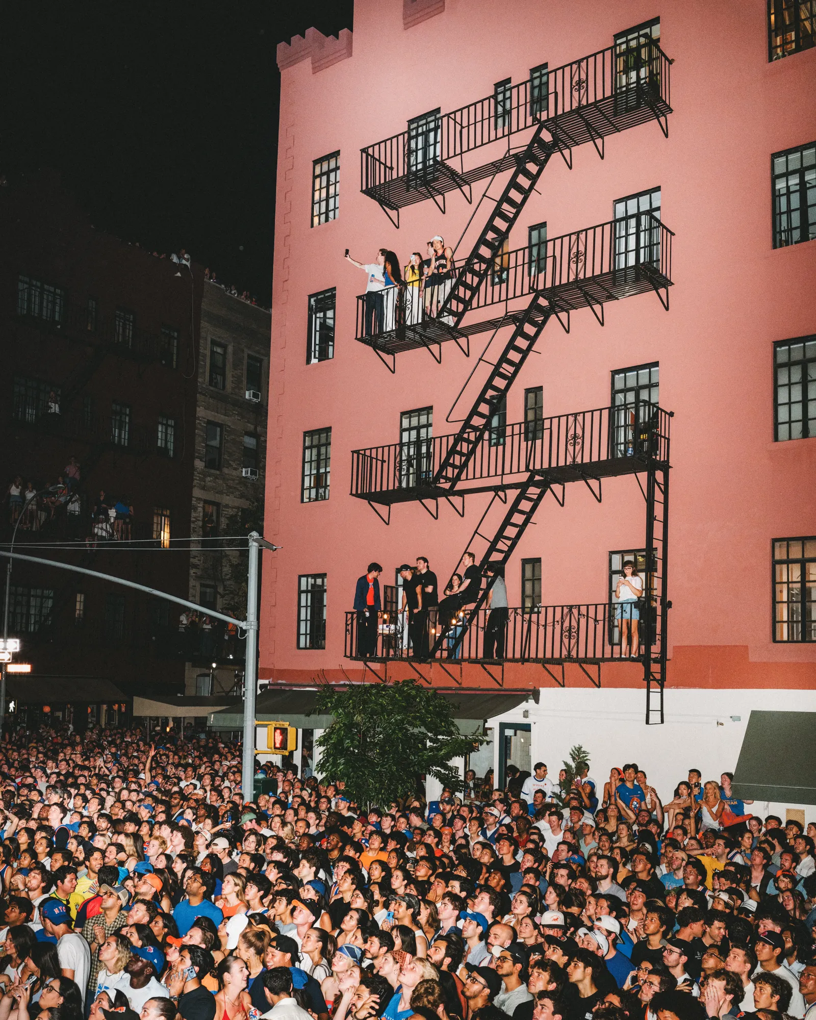 La fièvre retombe ! Les Knicks remportent un championnat et New York prend vie Une foule bondée de fans des Knicks remplit un coin de rue de New York pour regarder l'équipe de basket-ball lors du cinquième match de l'édition 2026...
