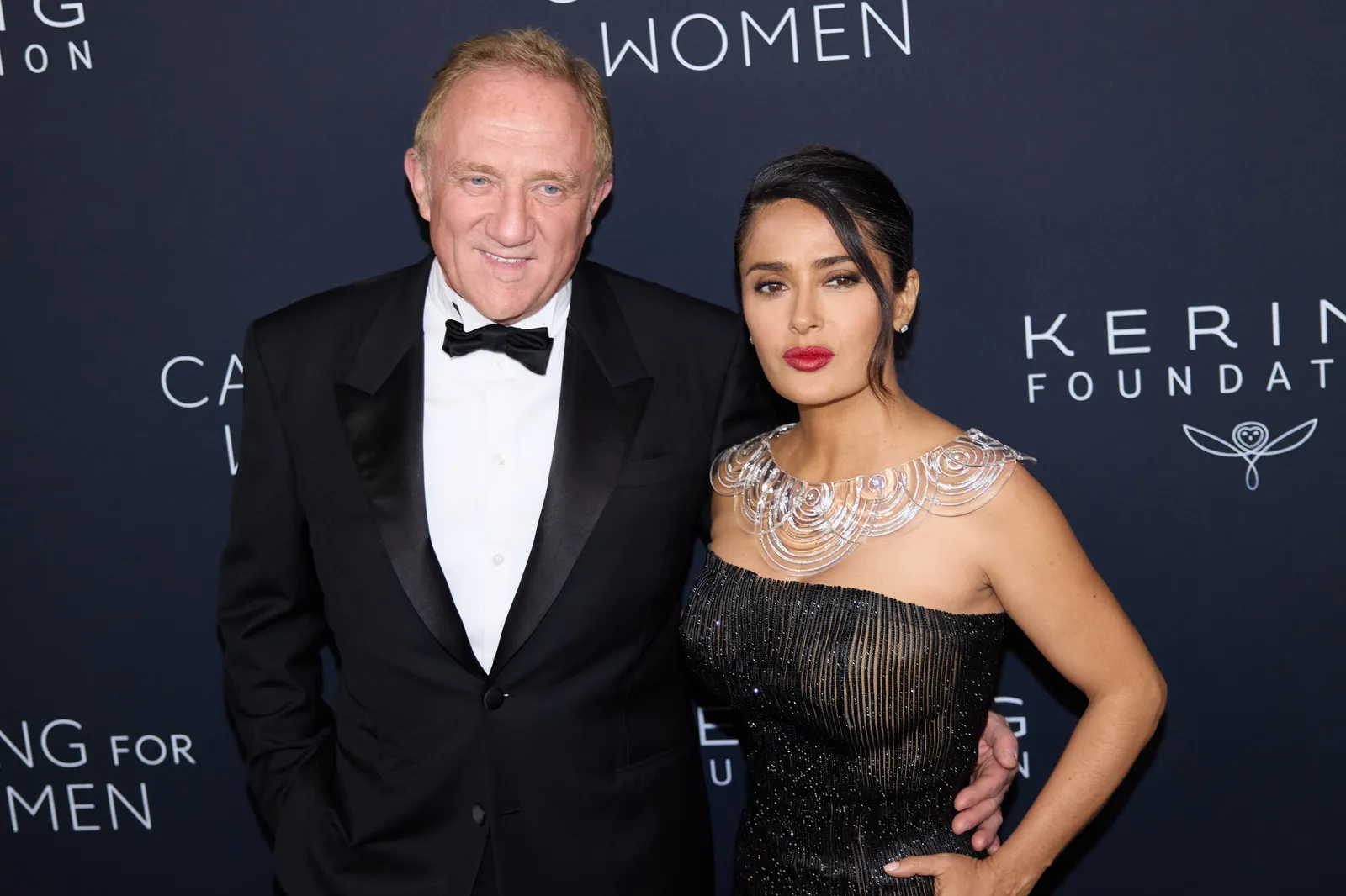 L'image peut contenir FrançoisHenri Pinault Salma Hayek Mode Tenue de soirée Vêtements Costume Personne Photobombing et robe