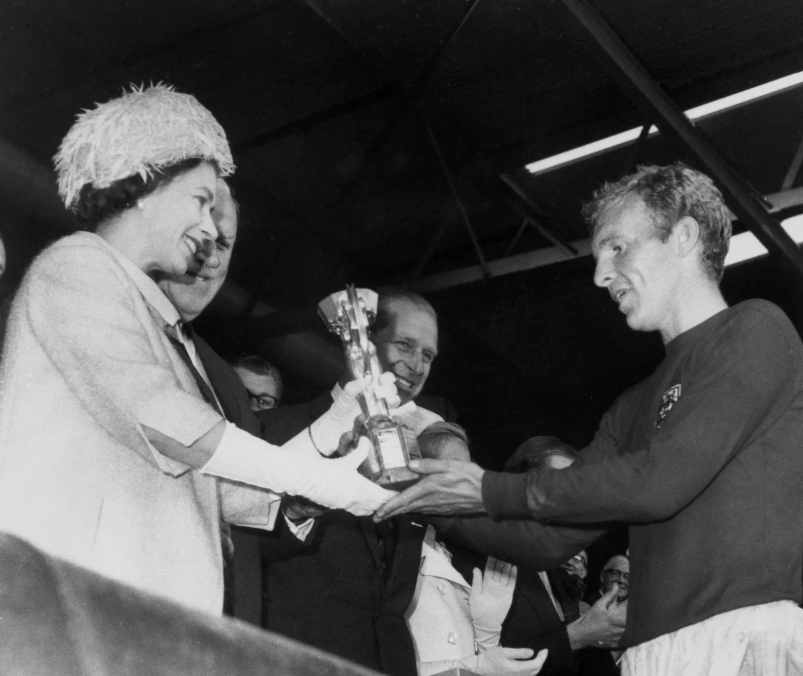 Coupe du monde 2026, Angleterre contre Argentine : le match qui fusionne football et famille royale L'image peut contenir Elizabeth II Bobby Moore Philip Tomalin James Wade Bruce R. McConkie et un appareil électrique