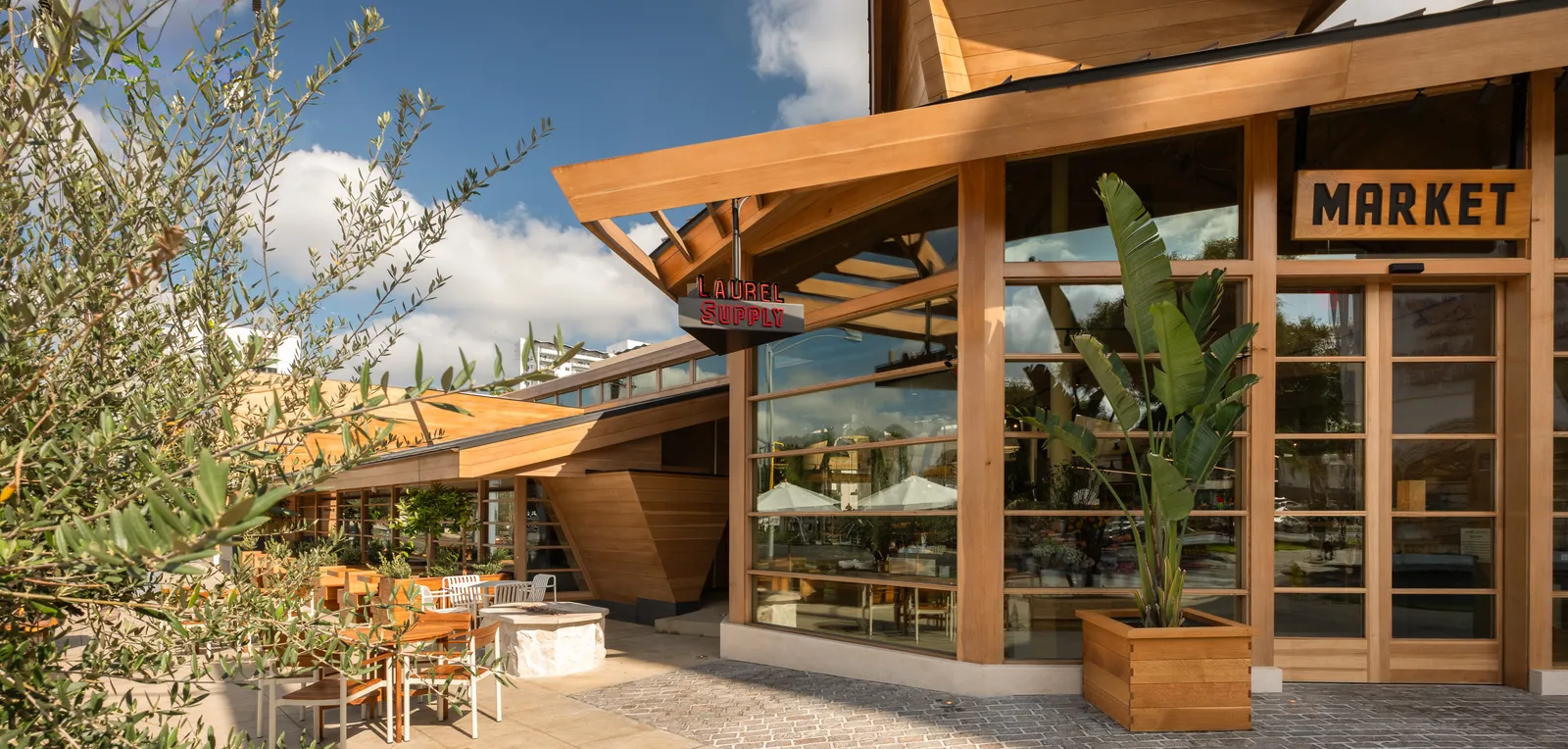 Dans certaines épiceries, les acheteurs portent des sacs fourre-tout. Chez Laurel Supply, ils apportent Chanel. L'image peut contenir : Intérieur, Design d'intérieur, Bois, Contreplaqué, Architecture, Bâtiment, Extérieur, Abri, Auvent et Ville.