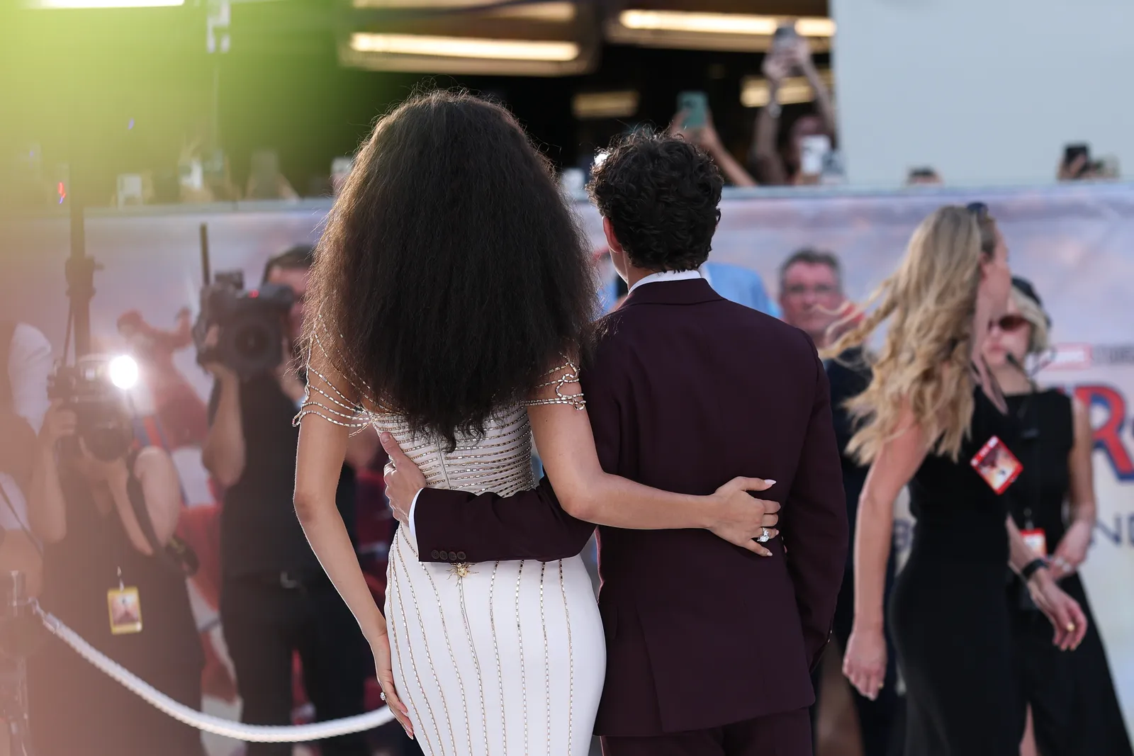 À l'intérieur de Beaverbrook, le site de la célébration du mariage glamour de Tom Holland et Zendaya L'image peut contenir des vêtements pour une personne adulte, une tenue de soirée, un costume, une robe, des câlins, des appareils électroniques, un téléphone portable et un téléphone.