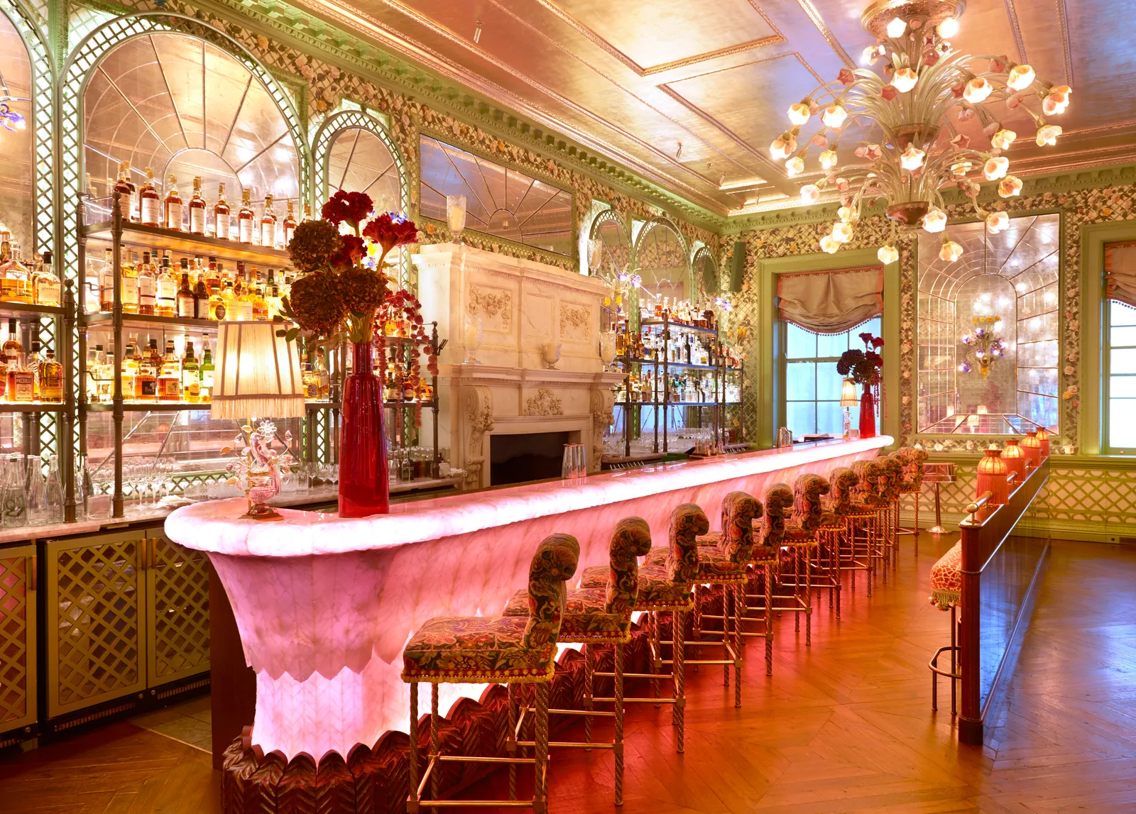 L'image peut contenir une chaise de pub, un mobilier, un design d'intérieur, un lustre, une lampe, un bar à alcool, un comptoir de bar et des boissons.