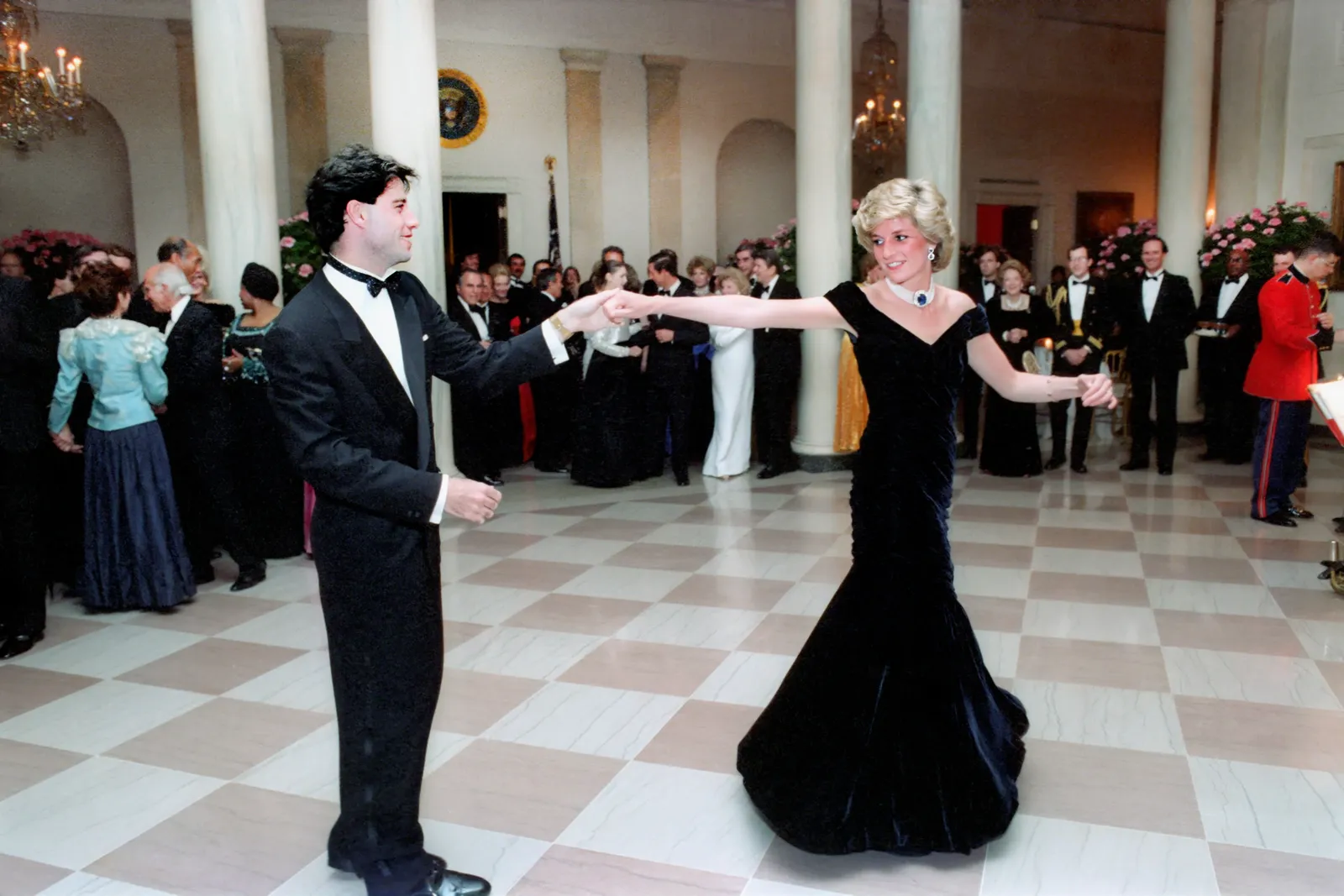 Une exposition au musée présentera les looks les plus légendaires de la princesse Diana L'image peut contenir John Travolta Diana Princesse de Galles Rupert Hambro La Parka Vêtements Tenue de soirée Costume et robe