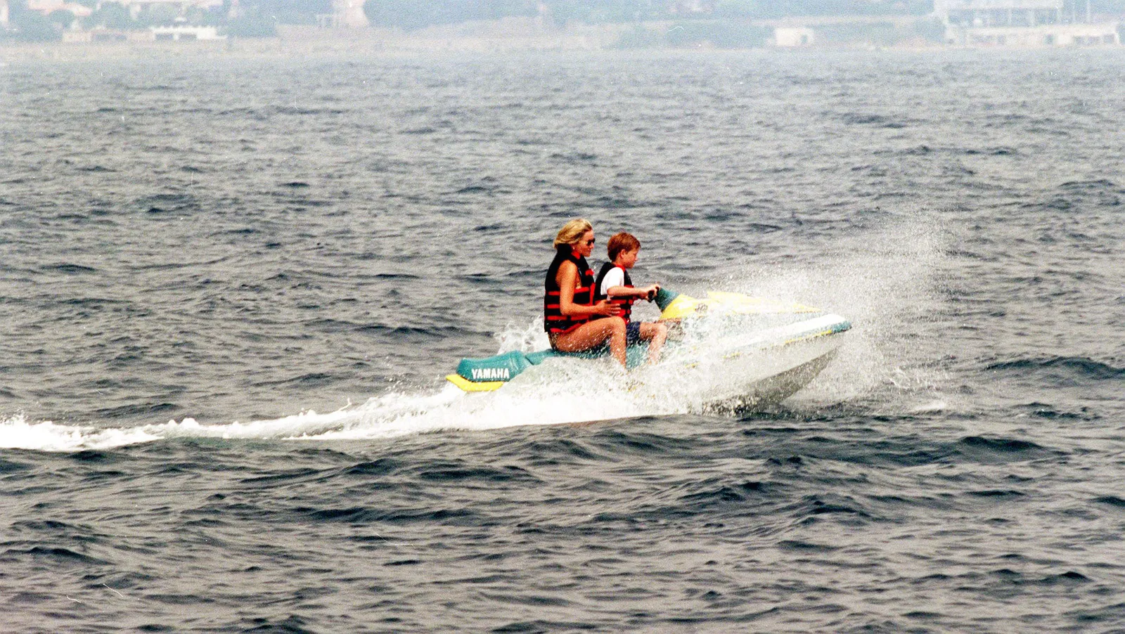 Un « coup du sort » a changé l'été dernier de la princesse Diana et modifié l'histoire Diana, princesse de Galles, portant un gilet de sauvetage par-dessus son maillot de bain et des lunettes de soleil, monte sur un jet ski avec le prince Harry...