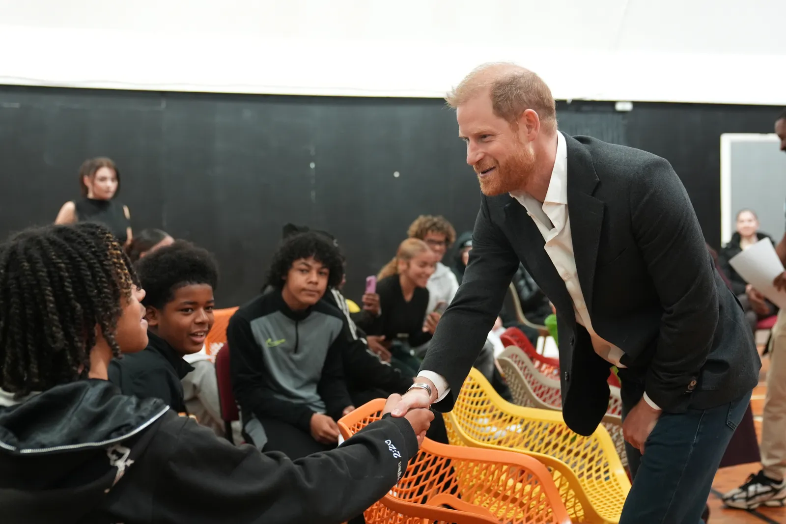 L'image peut contenir le visage du prince Harry, duc de Sussex, tête heureuse, personne, sourire, photographie adulte, portrait et vêtements.