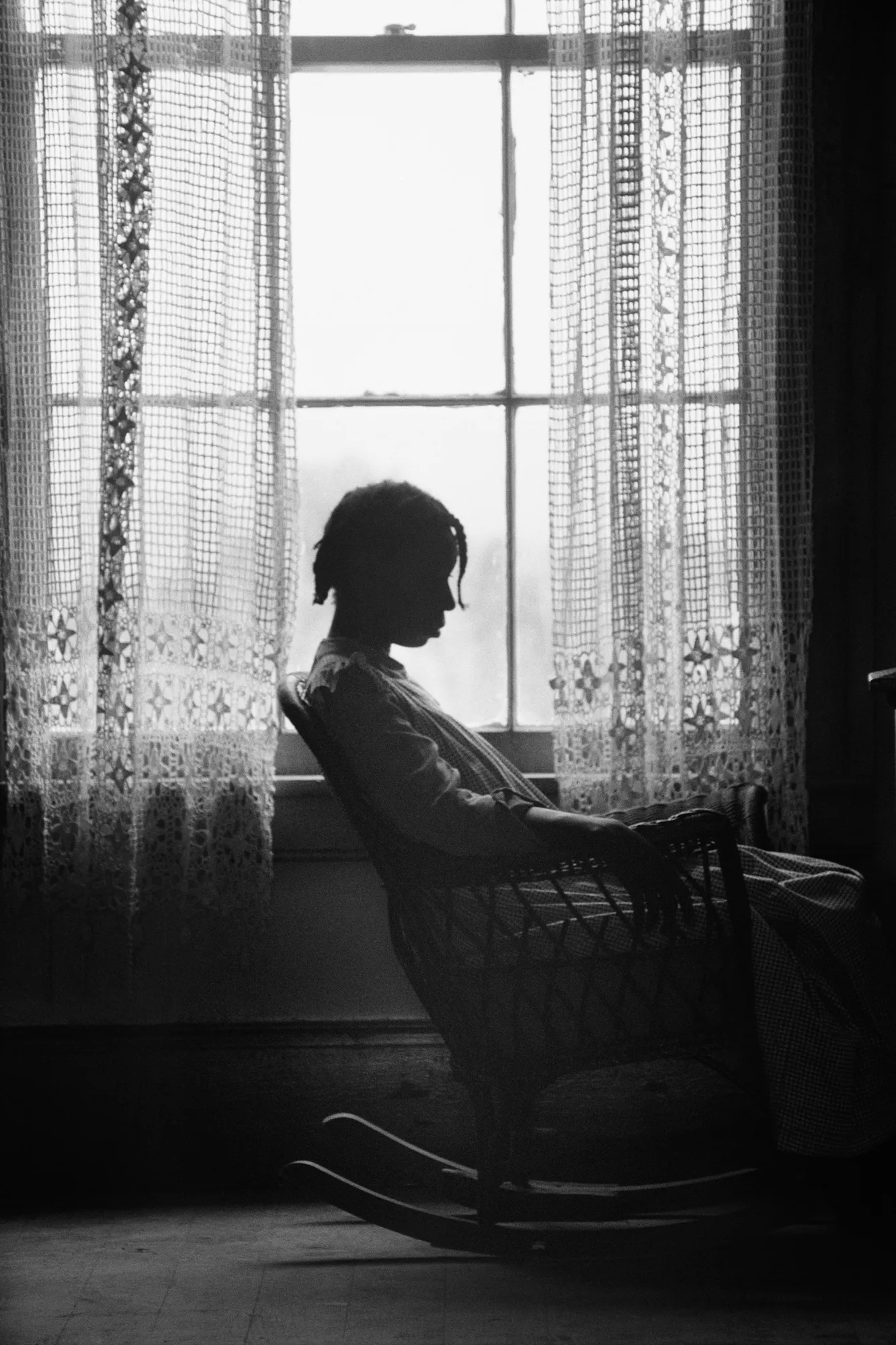 L'objectif est plus puissant : le meilleur de Gordon Parks L'image peut contenir une silhouette adulte personne rideau meubles chaise visage tête photographie portrait et fenêtre