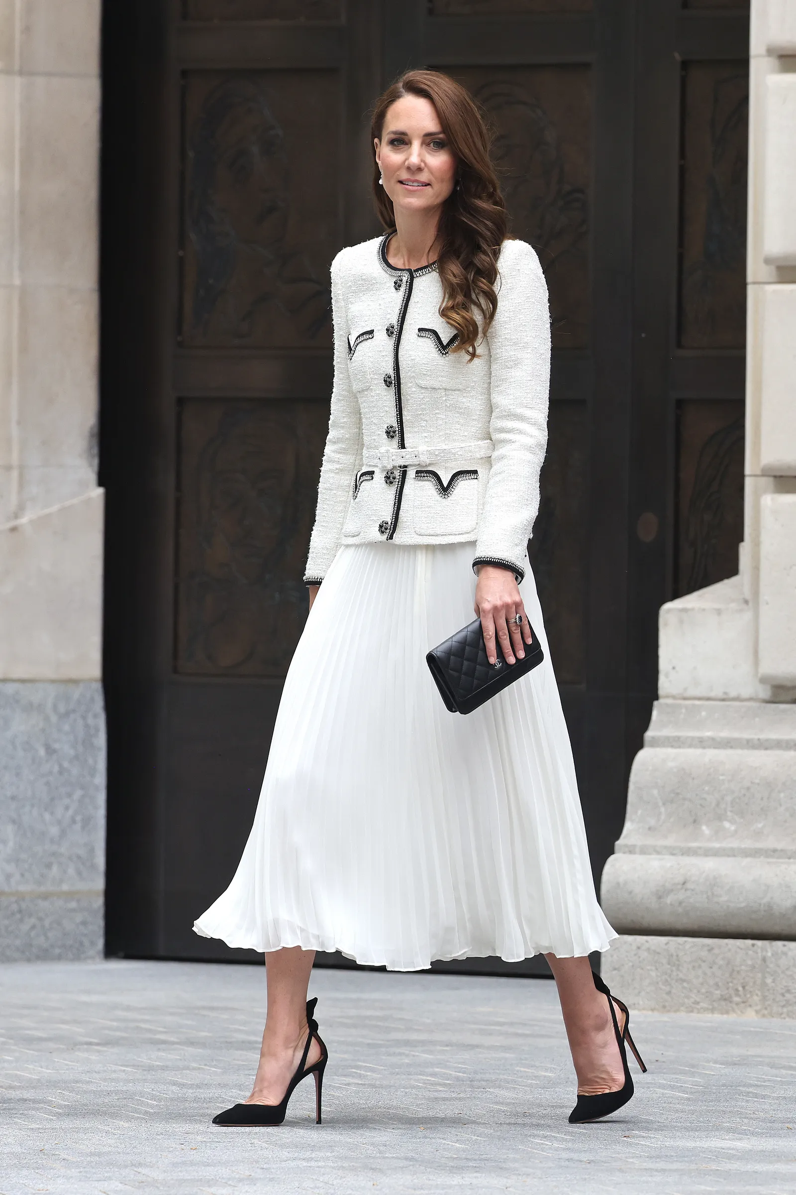 Kate Middleton est canalisée par la princesse Rajwa de Jordanie lors d'un événement caritatif L'image peut contenir des vêtements à manches longues, jupe, manteau, personne adulte, pantalon, robe, vêtements de cérémonie, costume et chaussures.