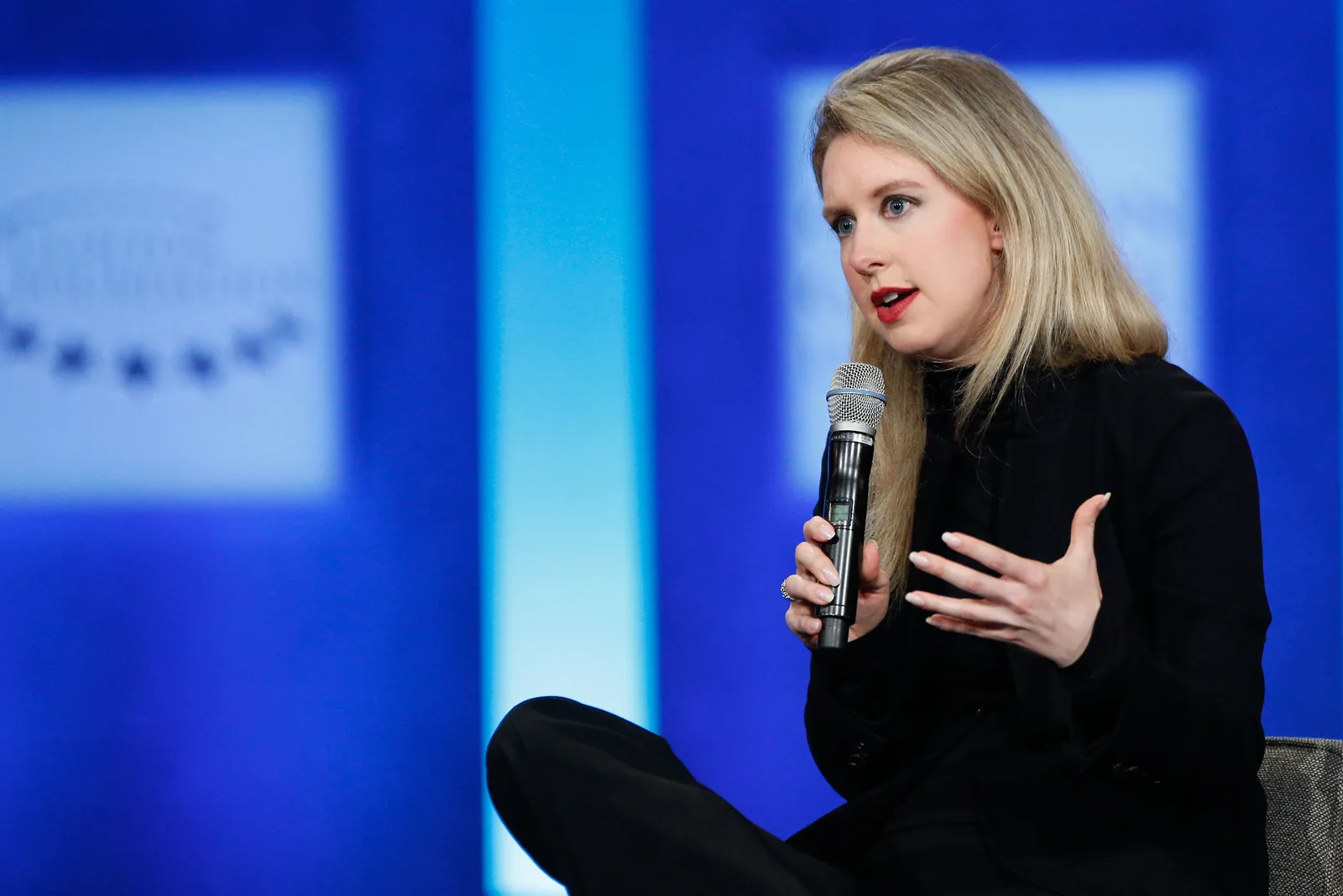 Vous pouvez voir tout ce que vous devez savoir sur Elizabeth Holmes en regardant ses vêtements L'image contient peut-être Elizabeth Holmes Appareil électrique Microphone Personnes Personne Foule Adulte Cheveux blonds et artiste interprète ou exécutant