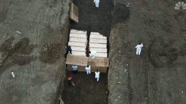 Aux Etats-Unis, des hommes en blouse creusent des tranchées pour enterrer les victimes pauvres ou sans famille