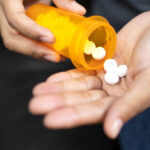 Man Pouring Drugs into Hand Medicine Aspirin