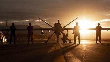 432nd Wing/432nd Air Expeditionary Wing Airmen pose with an MQ-9 Reaper for a photo at Creech Air Force Base, Nev., Nov. 19, 2019. The MQ-9 and its aircrew are one of the most demanded U.S. Air Force assets due to its ability to be employed primarily against dynamic targets and secondarily as an intelligence collection asset. (U.S. Air Force photo by Airman 1st Class William Rio Rosado)