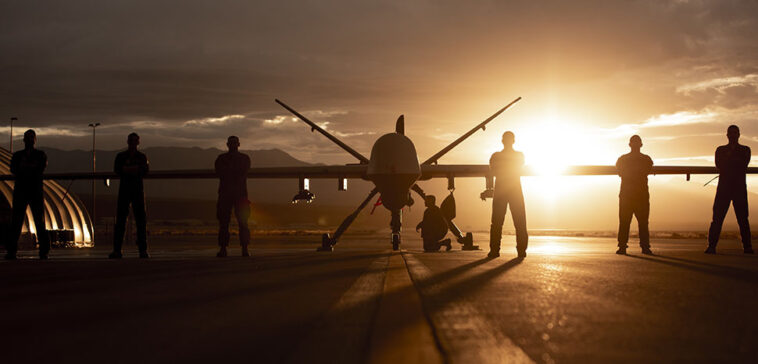 432nd Wing/432nd Air Expeditionary Wing Airmen pose with an MQ-9 Reaper for a photo at Creech Air Force Base, Nev., Nov. 19, 2019. The MQ-9 and its aircrew are one of the most demanded U.S. Air Force assets due to its ability to be employed primarily against dynamic targets and secondarily as an intelligence collection asset. (U.S. Air Force photo by Airman 1st Class William Rio Rosado)