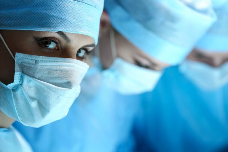 Les médecins mettent en garde contre une menace imminente : un « pipeline brisé » pourrait signifier l’extinction des chirurgiens-scientifiques Female Surgeon Looking at Camera