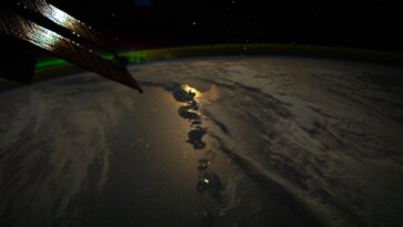 Vue à couper le souffle de l'astronaute : Moonglint, les Aléoutiennes volcaniques et les aurores boréales