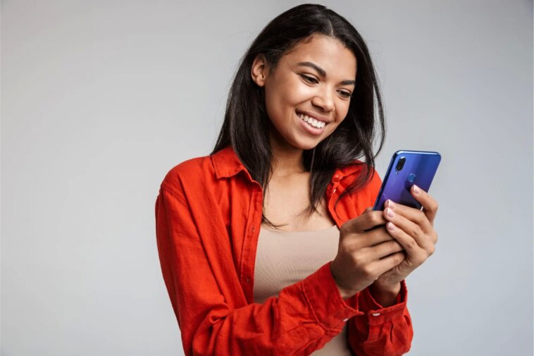 Attentes et réalité – Les gens apprécient-ils davantage les interactions sociales ou le temps passé devant un écran ? Smiling Woman on Phone