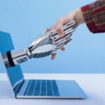 Les robots rendront-ils les travailleurs plus paresseux ? Human Robot Shaking Hands Laptop