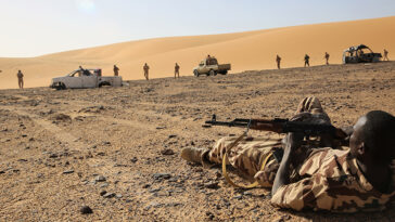 cc U.S. Department of Defense Current Photos, modified, https://flickr.com/photos/39955793@N07/33314871061/in/photolist-SKVquD-9LvVWX-8Vm6b6-FCwxZK-2kHqTvk-2kC4vcX-2ja2cVm-FG6FMu-71yVxb-3Hy59P-mwDspo-FjhaiN-FJozUv-FJozok-9dLKzn-FG6GbA-FCwyDF-EP993e-ENX2Cd-X3q3GB-EP98gK-2oA8pgx-8EVRmL-2jFi9d8-8Gio6M-2oA2xJU-DzoqrC-8Gmyn3-2kU1wD5-2j3oQVe-2opMBpV-9oyg3T-2orzZtY-2opGsYJ-2jxX8Au-k1PoVP-2jxSP1C-8vxYFf-2nnE8Wq-rQAXGH-8vy15L-8vxZxf-FJoA98-2nnGyY2-8vAZxN-8vuVWr-8vuYok-8vuXDD-8vxZkf-88LKA1, A Chadian Army Soldier who is a simulated casualty awaits medical assistance during a simulated assault in Faya-Largeau, Chad Mar. 3, 2017 as part of Flintlock 17. Flintlock is an annual special operations exercise involving more than 20 nation forces that strengthens security institutions, promotes multinational sharing of information, and develops interoperability among partner nation in North and West Africa. (Army photo by Sgt. Derek Hamilton)