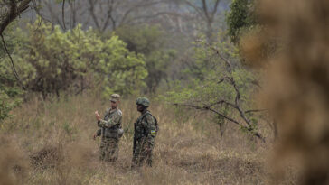 cc US Africa Command, modified, U.S. Army Staff Sgt. James Hartenstein, combat engineer 402nd Engineer Company(Sapper), gives feedback to a member of the Rwanda Defence force during the field training exercise of Exercise Shared Accord 2019, in Gabiro, Rwanda, Aug. 25, 2019. SA 19, which runs Aug. 14-28, is focused on bringing together U.S. and Rwandan forces, African partner militaries, allies and international organizations to increase readiness, interoperability, and partnership building between participating nations for peacekeeping operations in the Central African Republic. (U.S. Army Reserve photo by Sgt. Heather Doppke/79th Theater Sustainment Command), https://flickr.com/photos/africom/48941443818/in/photolist-2h1pudS-2h7dsZY-2h1pDeh-2h7fXrC-2h1qixs-2h7dwYQ-2h7frwX-2h7dvec-2h1px1L-2hyMxxP-2hyQnFG-2hyQwYQ-2h1iZuF-2hyMBuG-2hyQoZy-2hyRqZQ-2hyRona-2hyMESZ-2h1qAKy-2hyRBzY-2hyMyWv-2hyMxUR-2hyRvem-2hyRuTm-2hyMCgr-2hyQmQy-2hyQpfy-2hyMDKt-2hyRsTz-2hyQrRL-2hyMyNz-2hyQtLn-2hyMEhk-2hyMG9S-2h1qLDW-2h1hHb9-2h7fb61-2hyMApW-2hyQBZr-2hyRqmA-2hyRniM-2hyQoo8-2hyMGy9-2hyQvtL-2hyMEs5-2hyMHc8-2hyRqRi-2hyRpkT-2hyQn1o-2hyME3s