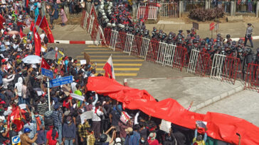 cc VOA Burma, public domain, https://commons.wikimedia.org/wiki/File:Protesters_against_the_military_coup.jpg, modified,