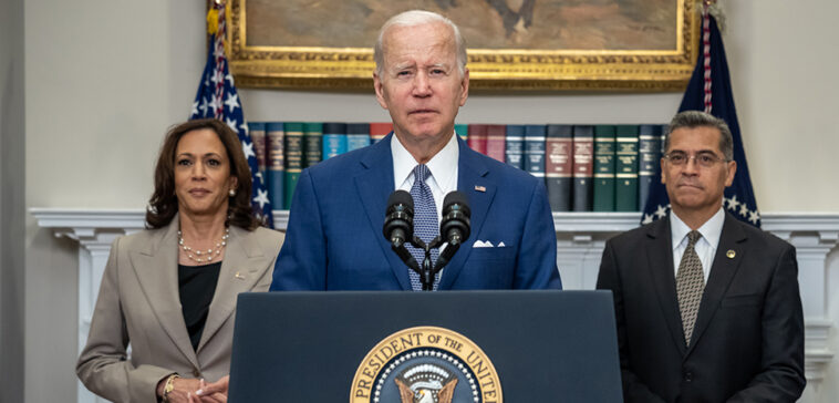 cc The White House, modified, https://commons.wikimedia.org/w/index.php?sort=last_edit_desc&search=president+biden+filetype%3Abitmap&title=Special%3ASearch&profile=advanced&fulltext=1&advancedSearch-current=%7B%22fields%22%3A%7B%22filetype%22%3A%22bitmap%22%7D%7D&ns0=1&ns6=1&ns12=1&ns14=1&ns100=1&ns106=1#/media/File:P20220708AS-0312_(52308746245)_(cropped).jpg ; President Joe Biden, joined by Vice President Kamala Harris, Secretary of Health and Human Services Xavier Beccera and Deputy Attorney General Lisa Monaco, delivers remarks in the Roosevelt Room of the White House Friday, July 8, 2022, prior to signing an executive order protecting access to reproductive healthcare services. (Official White House Photo by Adam Schultz)